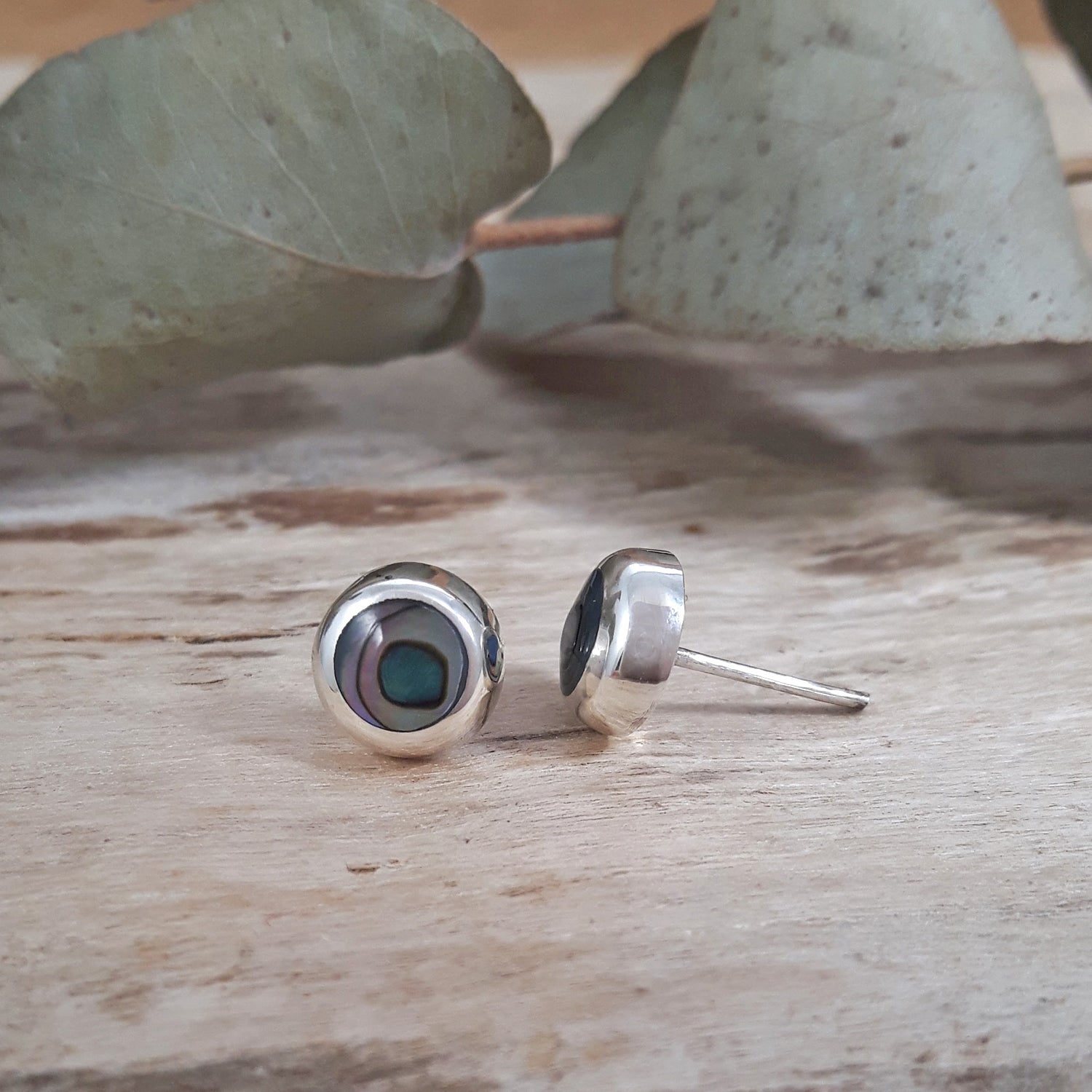 Side profile of 925 sterling silver abalone circle stud earring showing butterfly post fitting, iridescent dark teal shell.