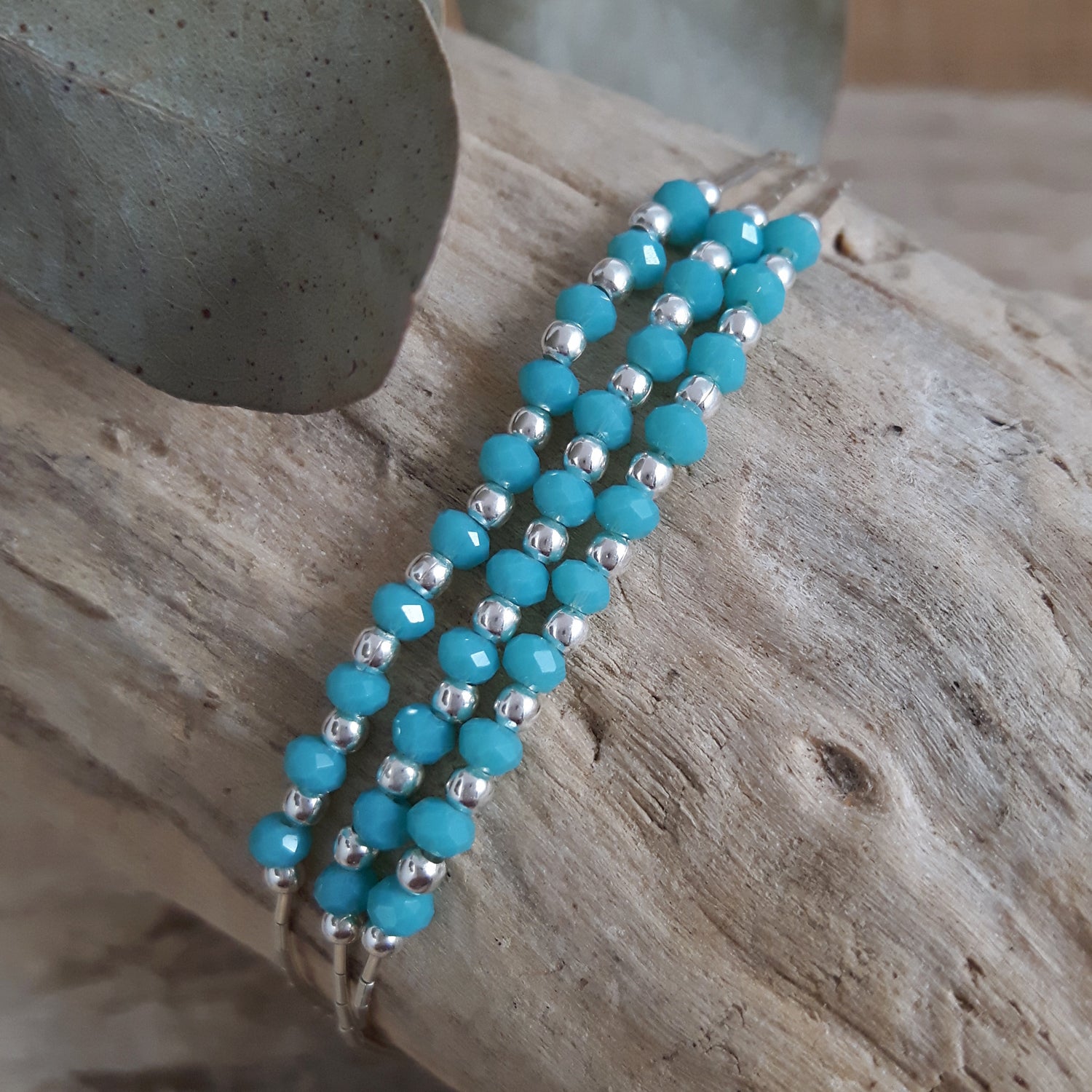 Blue Chalcedony beaded bracelet with sterling silver accents on a wooden surface