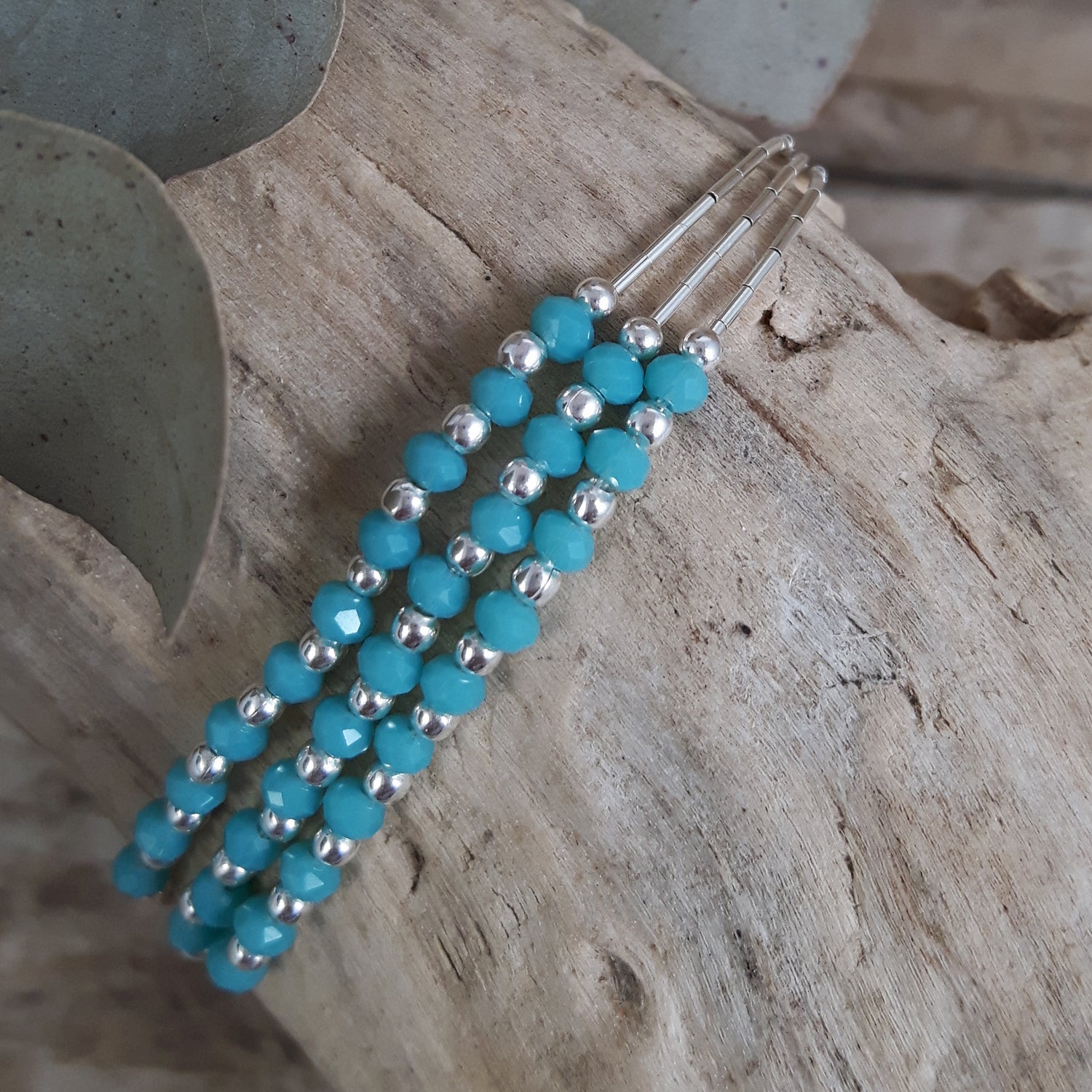 Blue Chalcedony and sterling silver beaded bracelet on a wooden surface