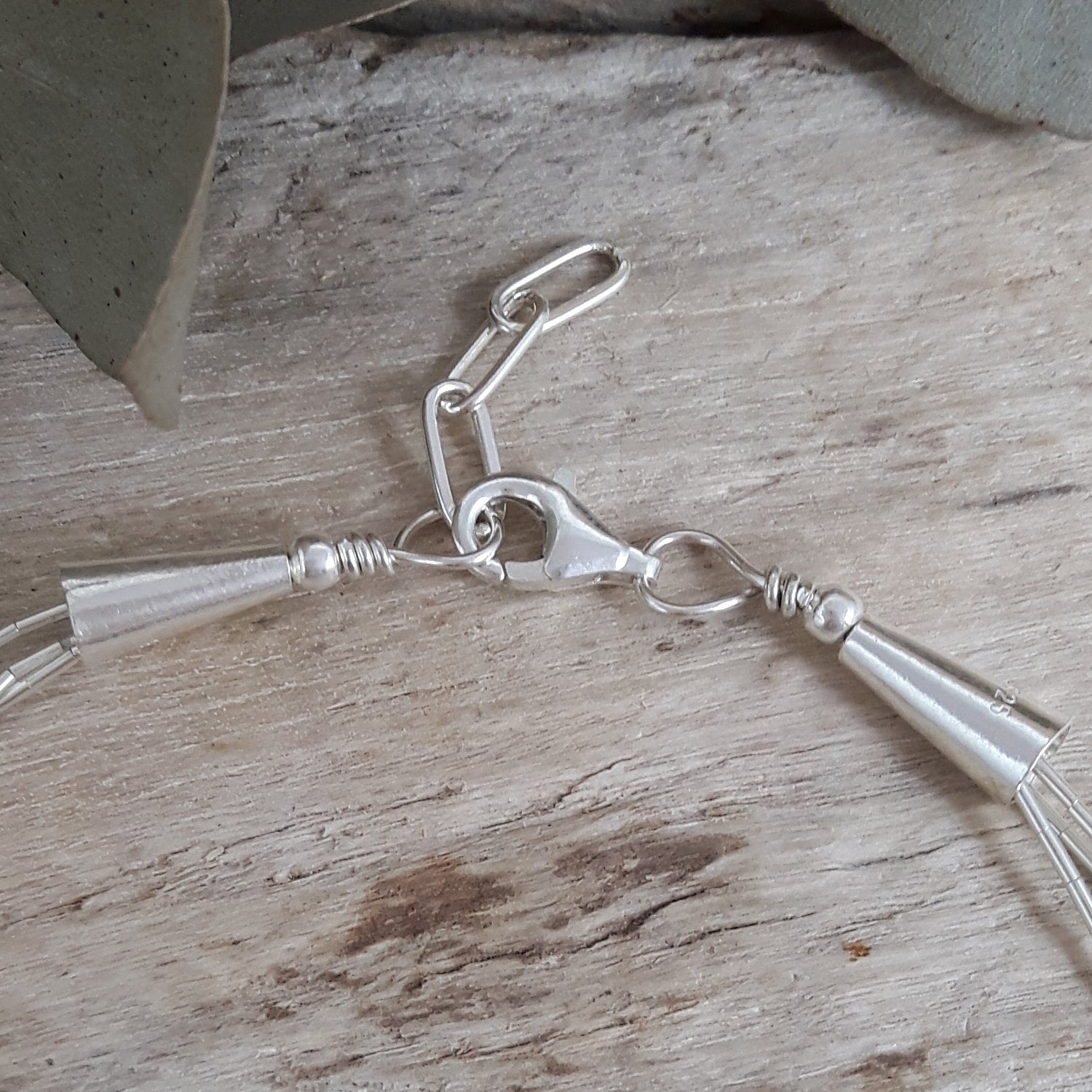 Sterling silver gemstone bracelet with clasp on a wooden surface