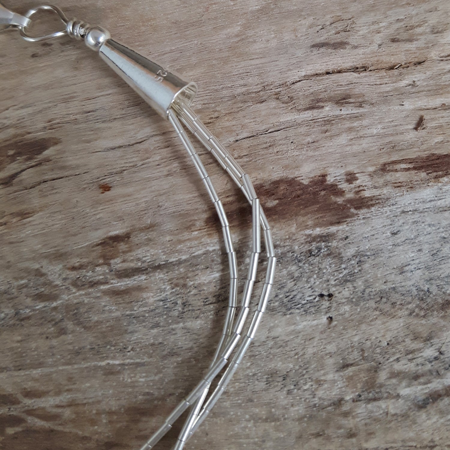 Sterling silver gemstone bracelet on a wooden surface
