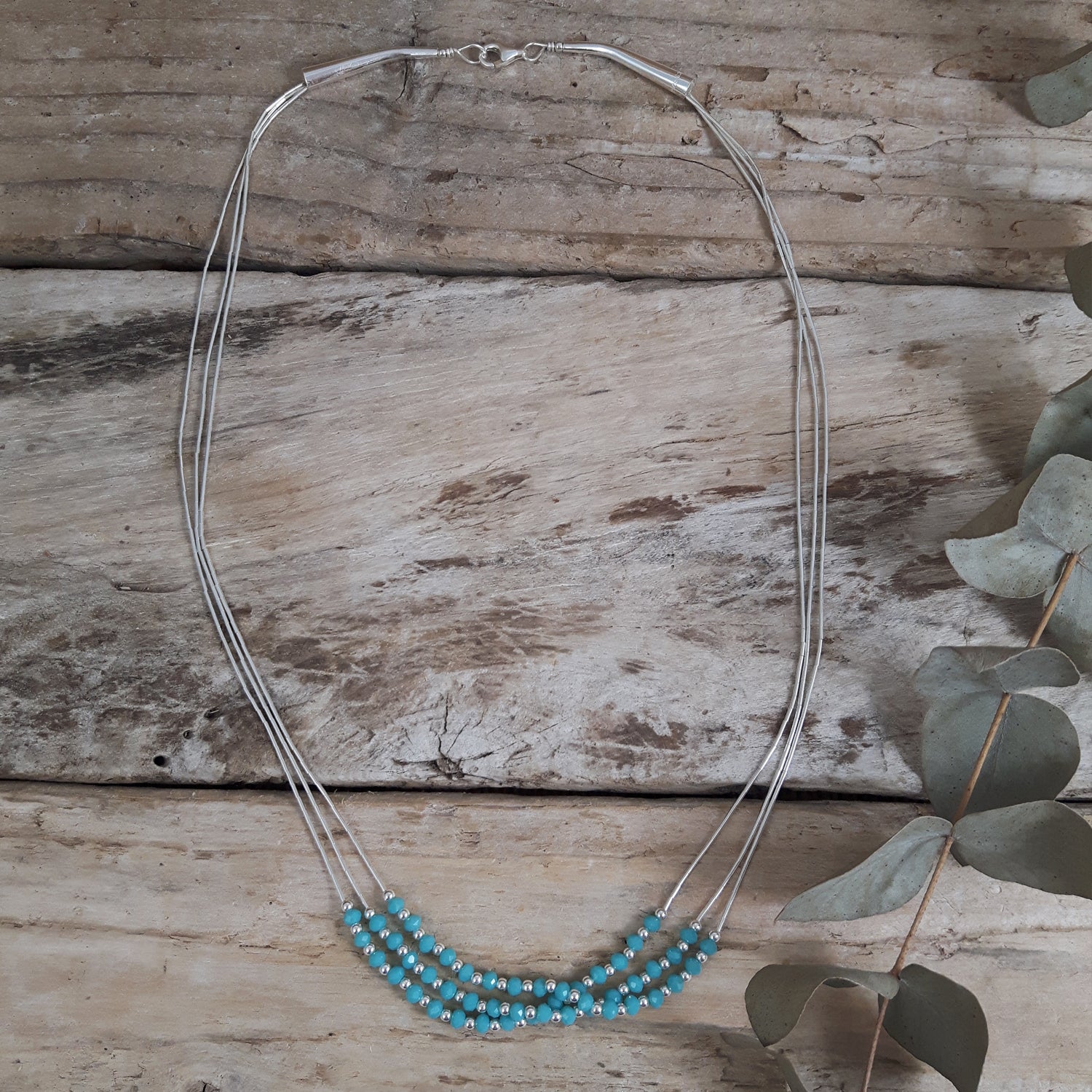 Necklace with blue chalcedony beads on a wooden surface
