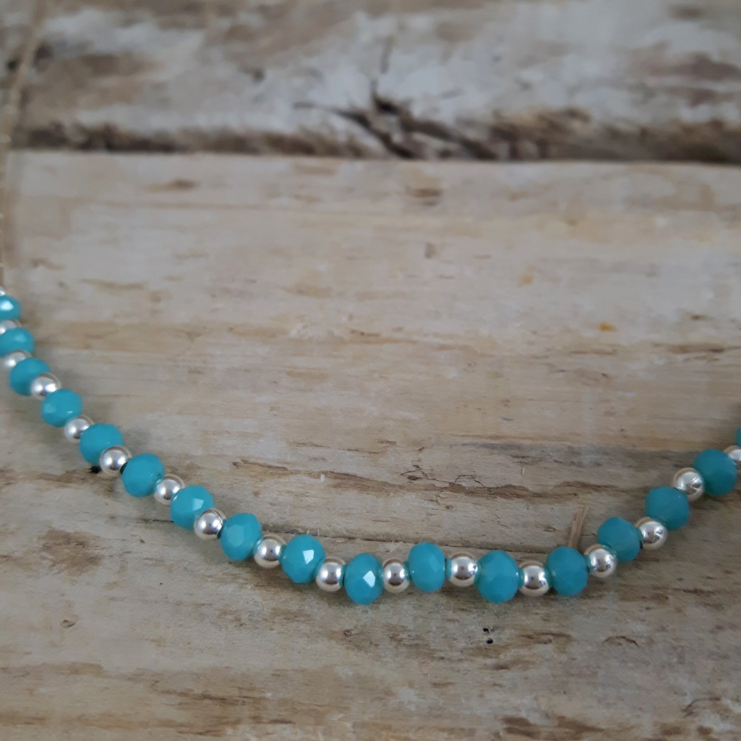 Necklace with blue chalcedony and sterling silver beads on a wooden surface