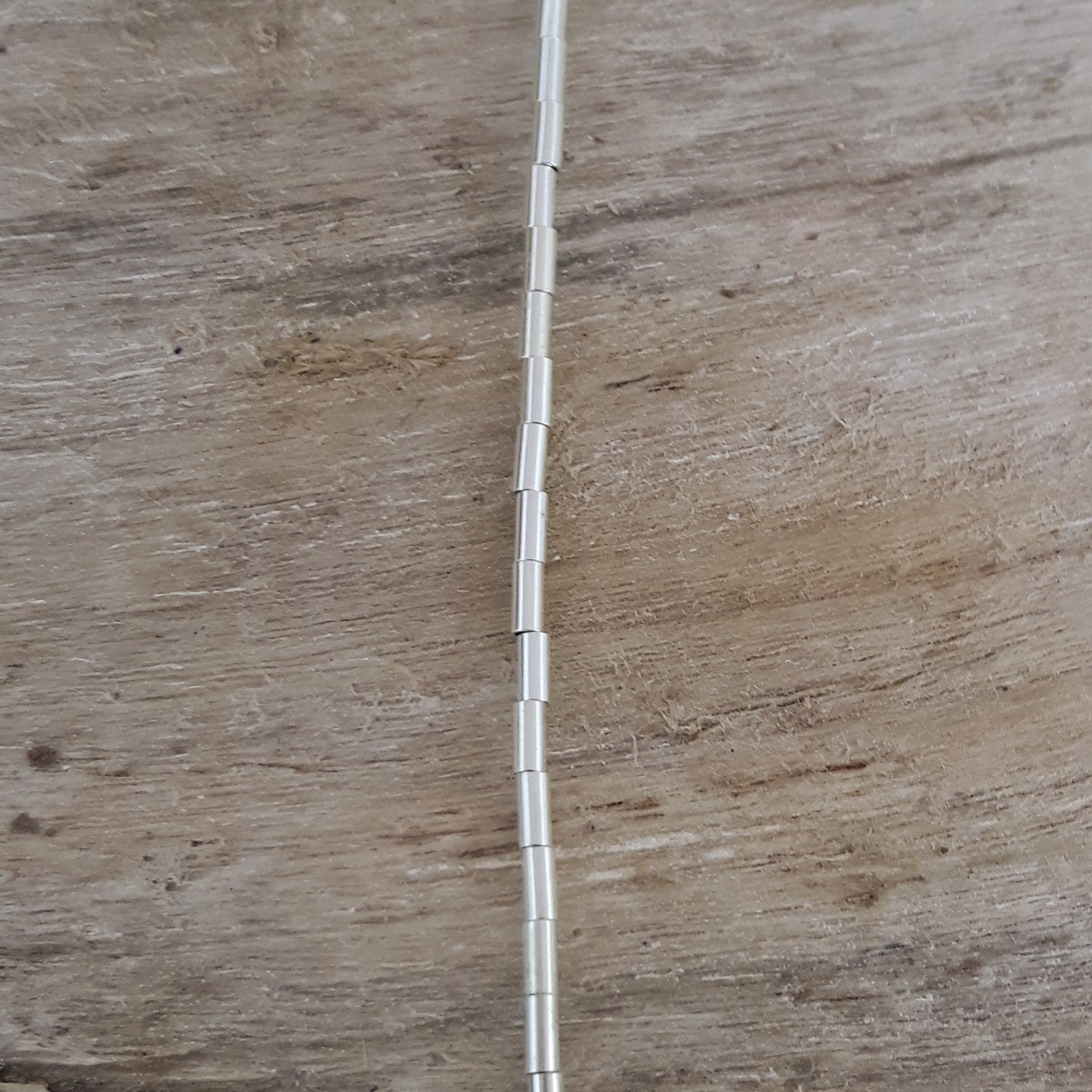 Sterling silver necklace on a wooden surface