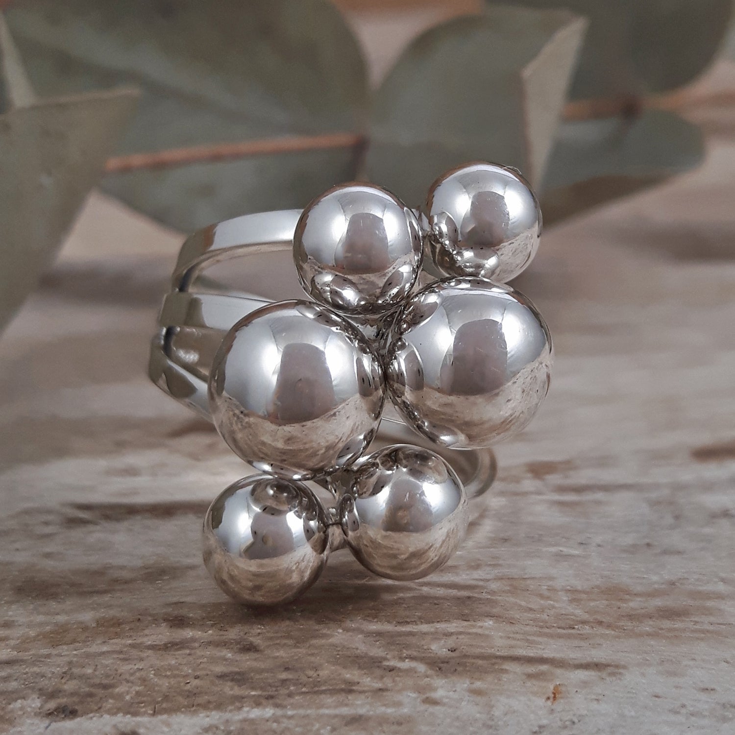 Sterling silver ring with spherical design on a wooden surface