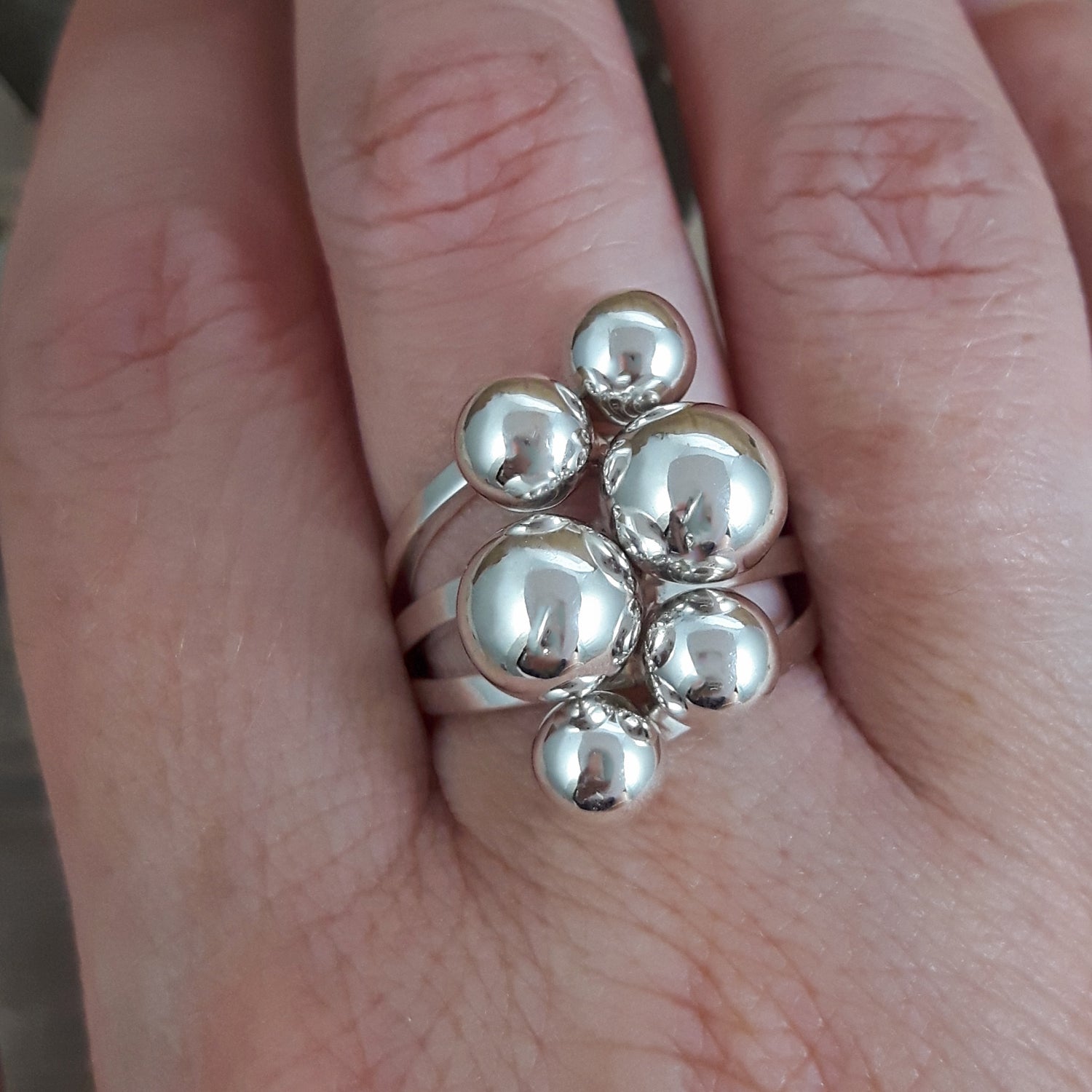 Sterling silver Calypso ring with spherical design on a finger