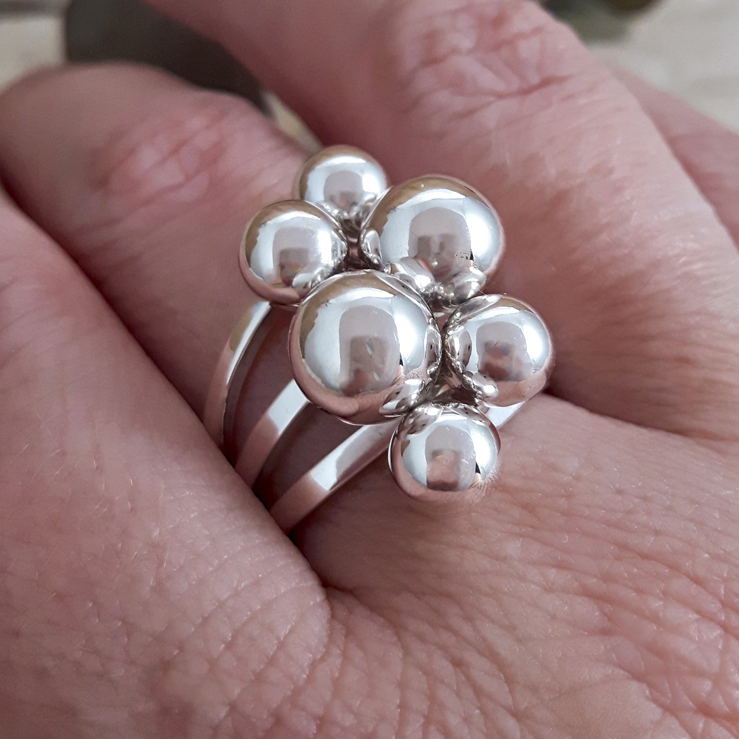 Calypso sterling silver polished ring with spherical design on a finger