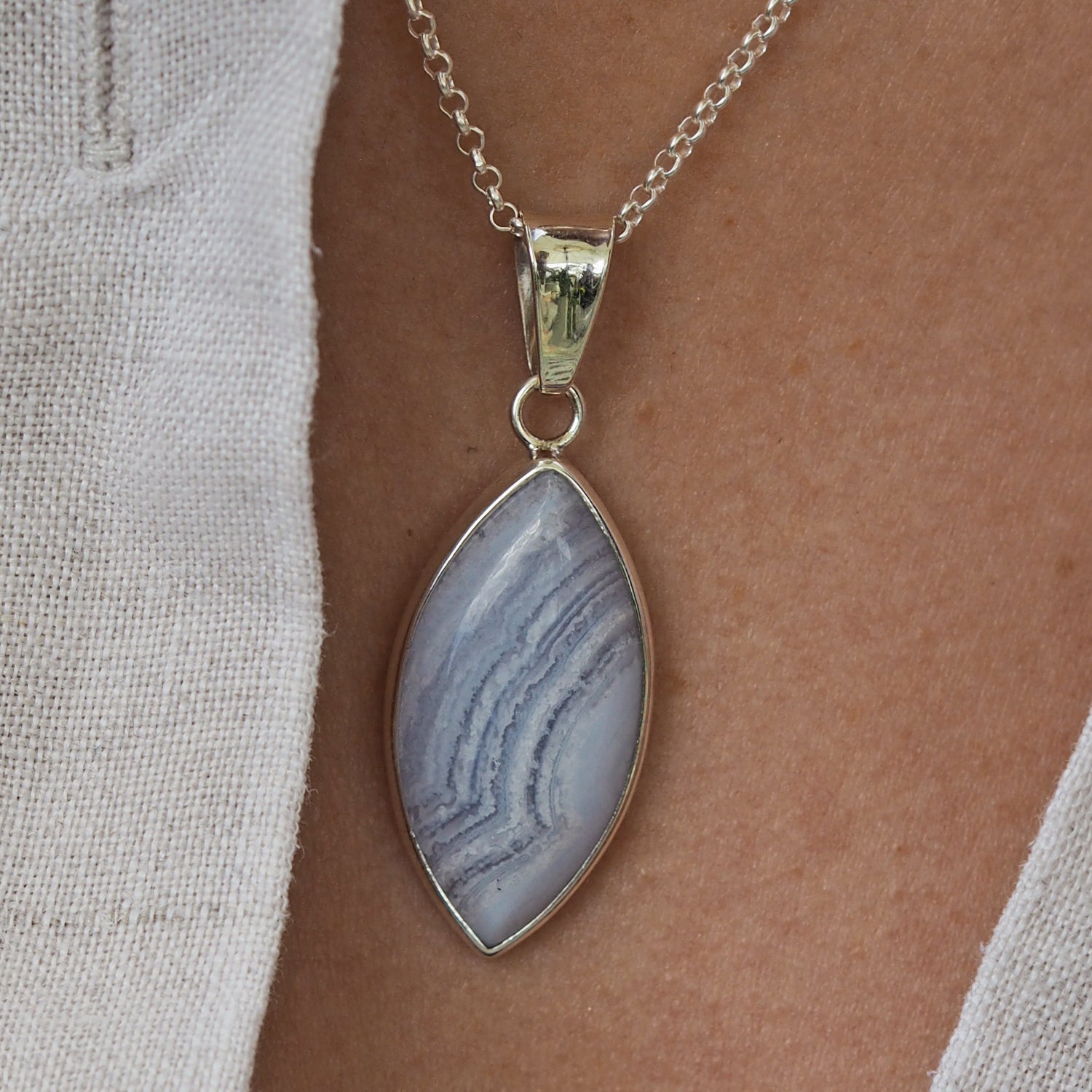 Unique blue lace agate gemstone pendant worn with a sterling silver chain