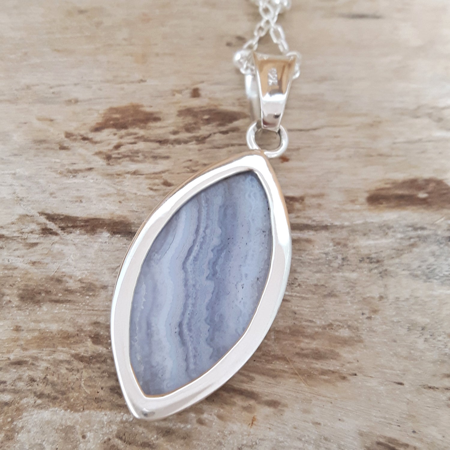 Back of a blue lace agate pendant on a sterling silver chain, a unique gift uk