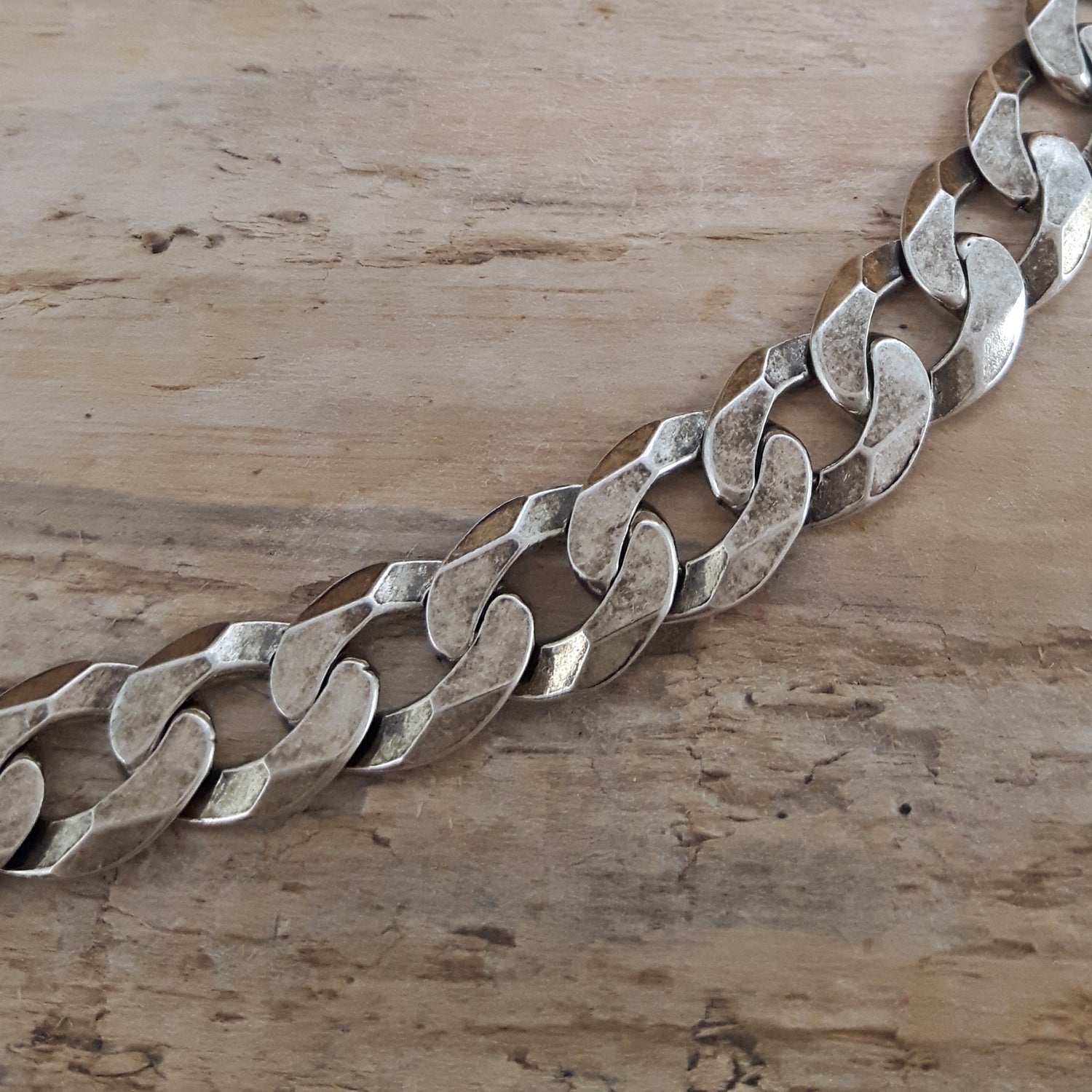 Close-up of sterling silver oxidised chain on a wooden surface