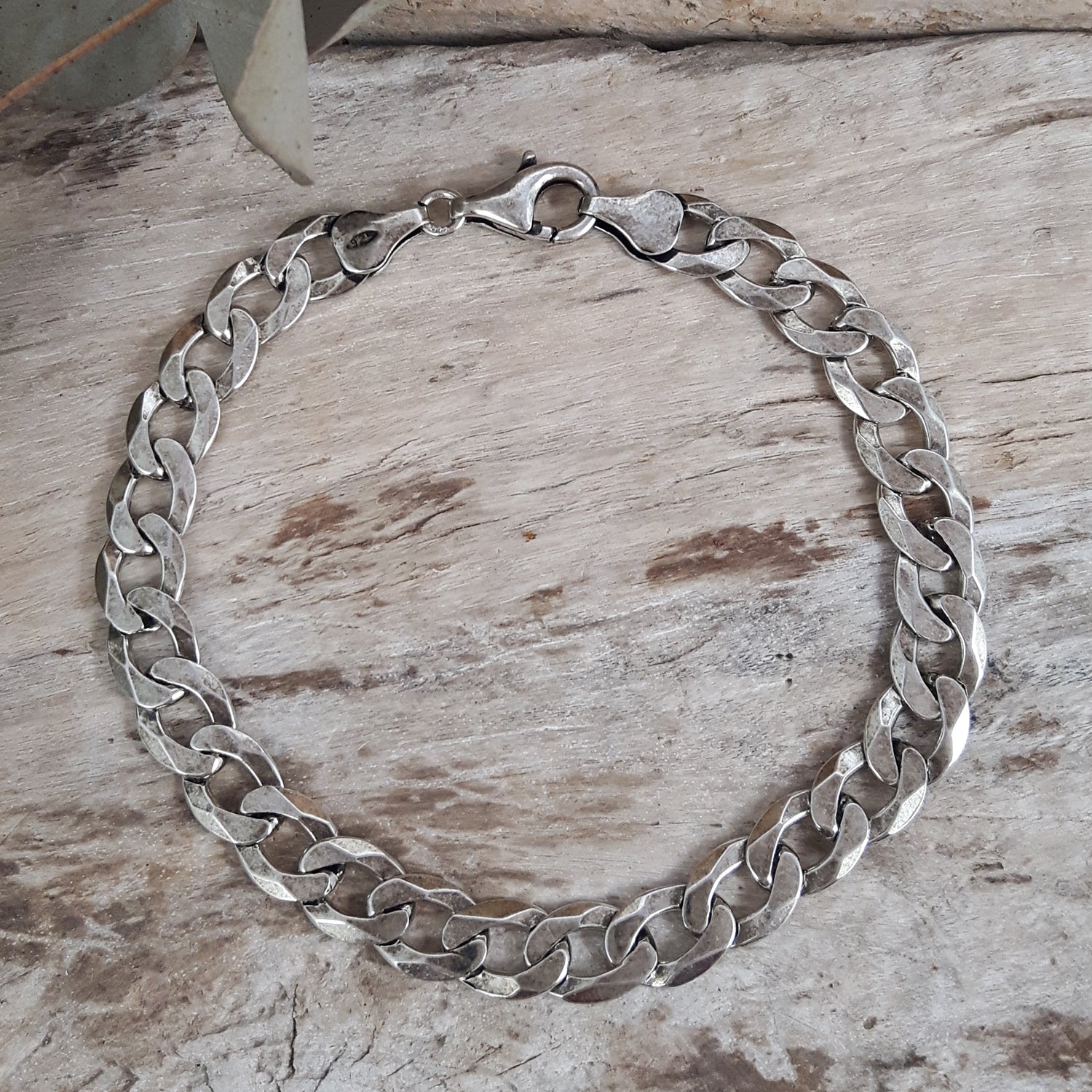 Oxidised sterling silver chain bracelet on a wooden surface