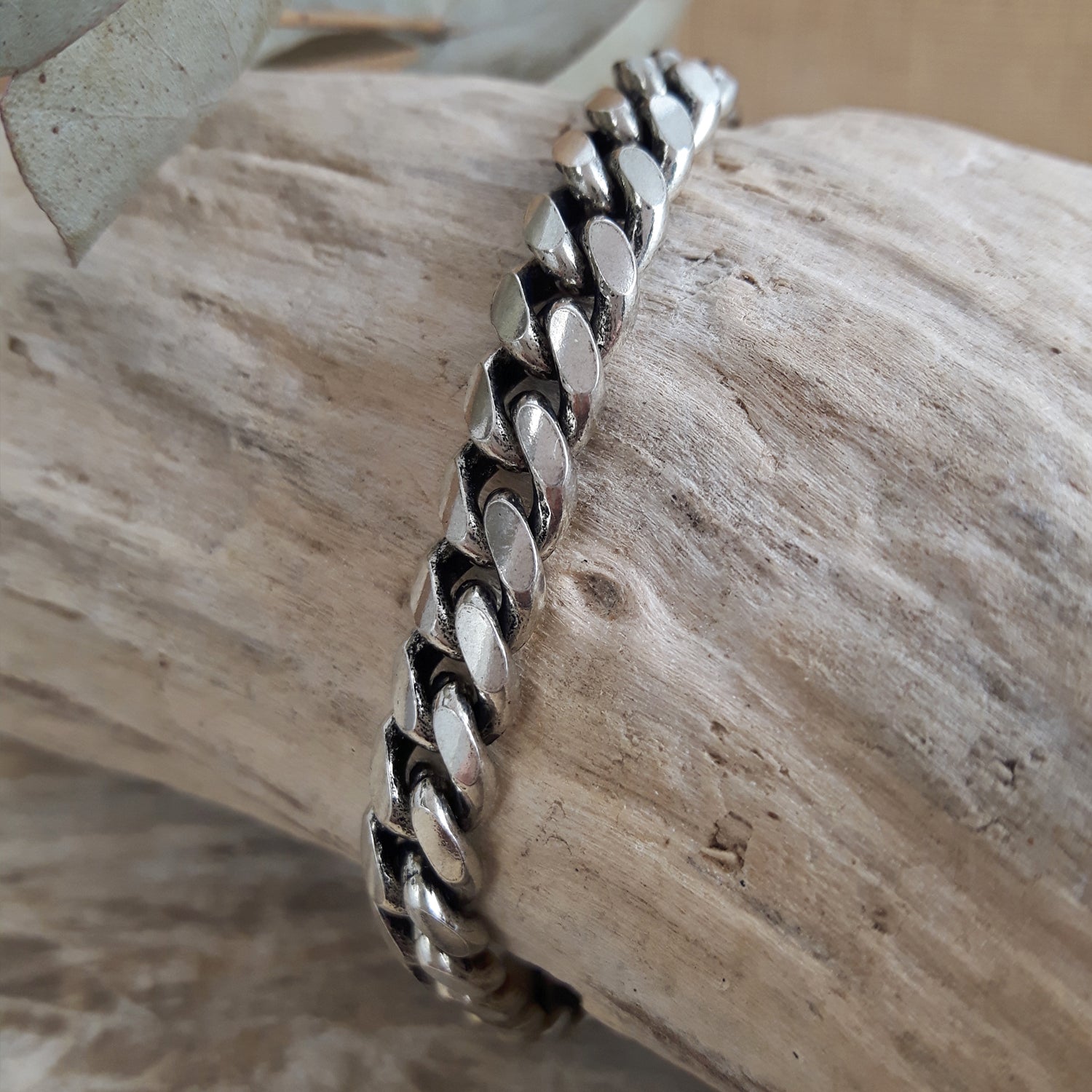 Sterling silver chain bracelet on a wooden surface