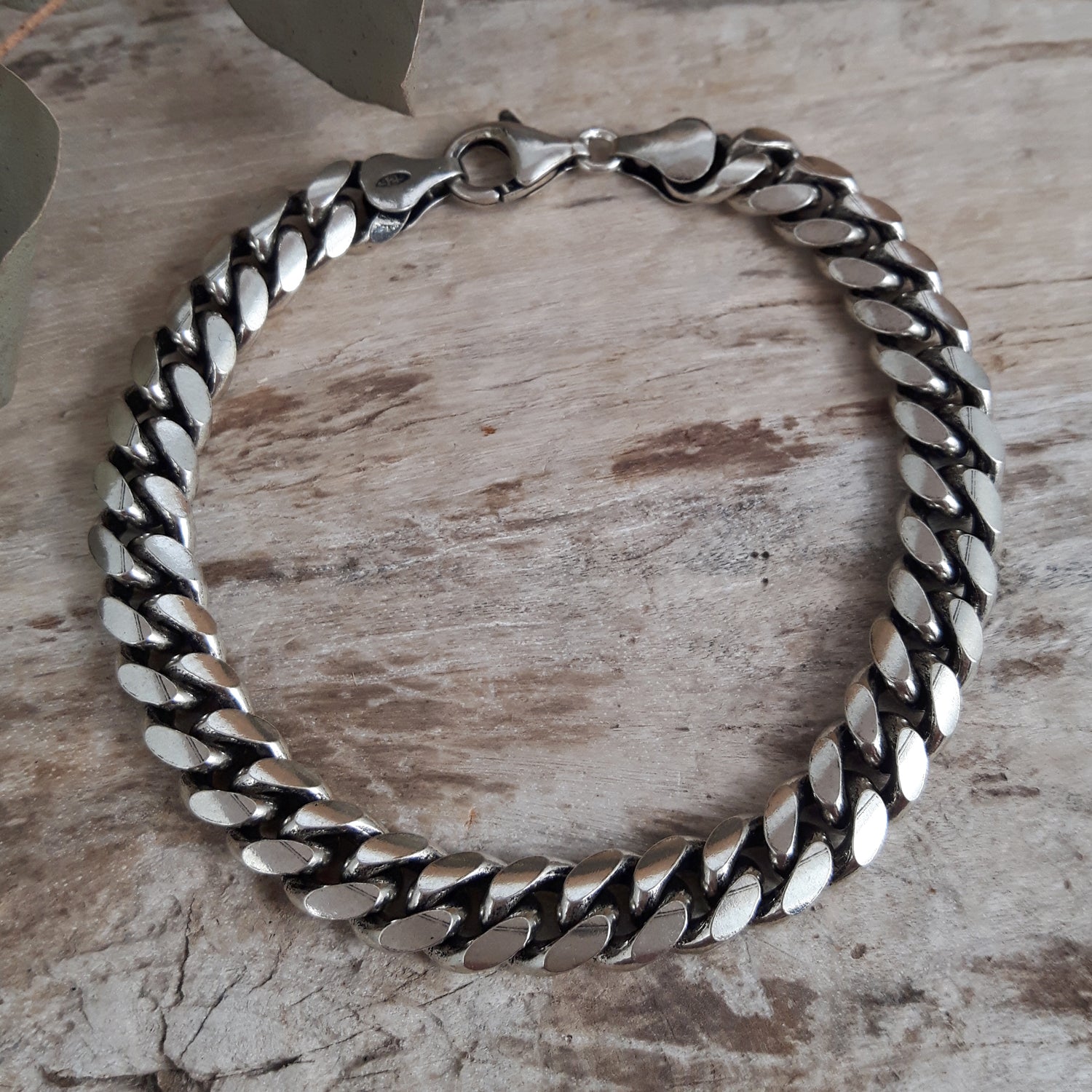 Sterling silver chain mens bracelet on a wooden surface