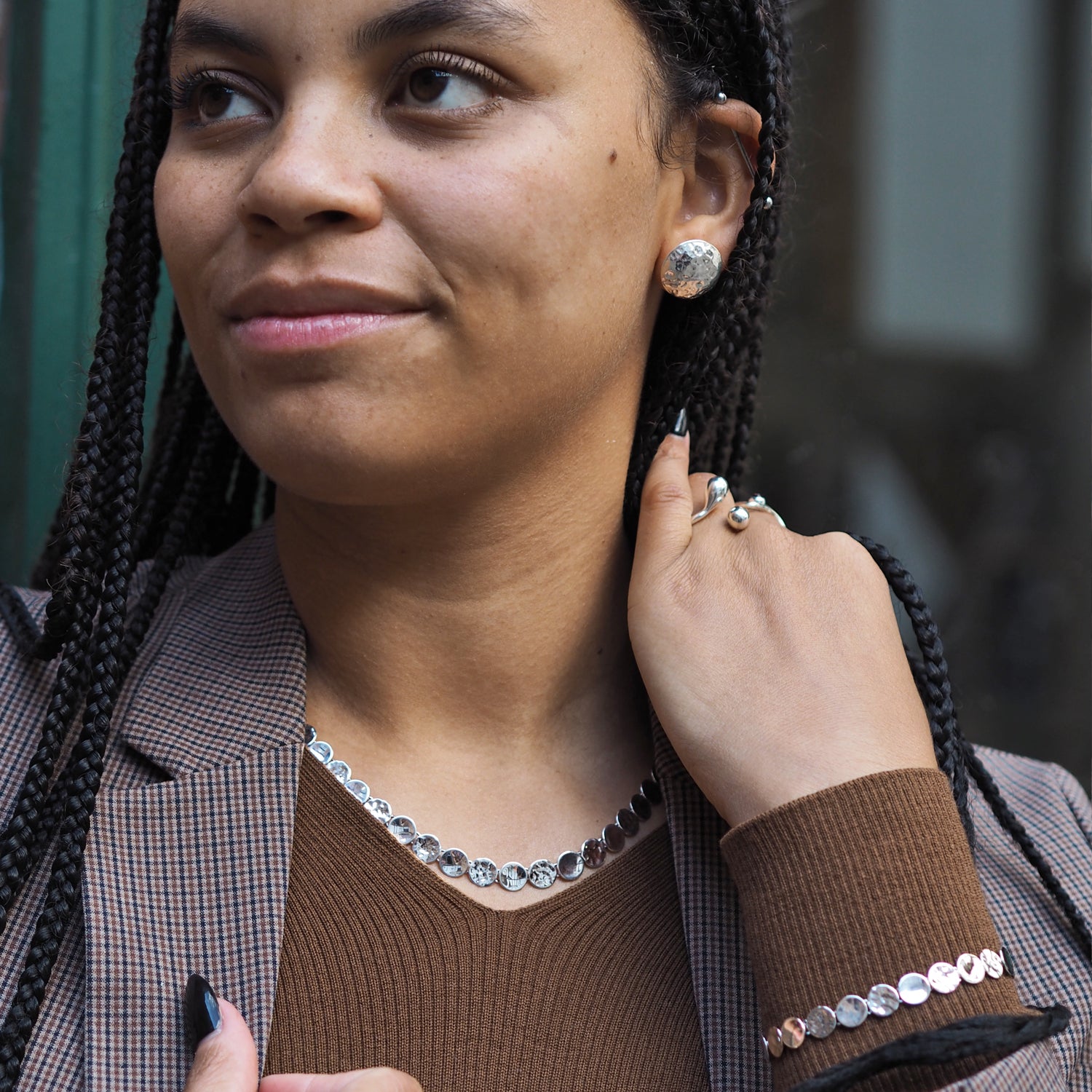 Woman adjusting her earring with a blurred background