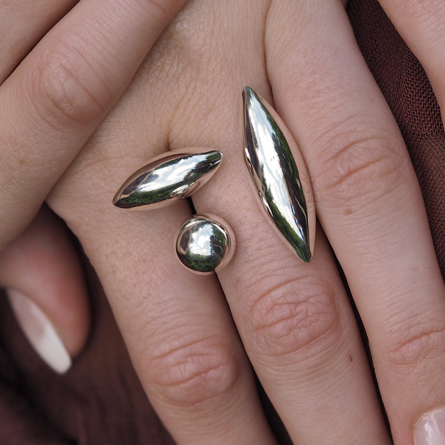 A sterling silver polished ring on a person's finger