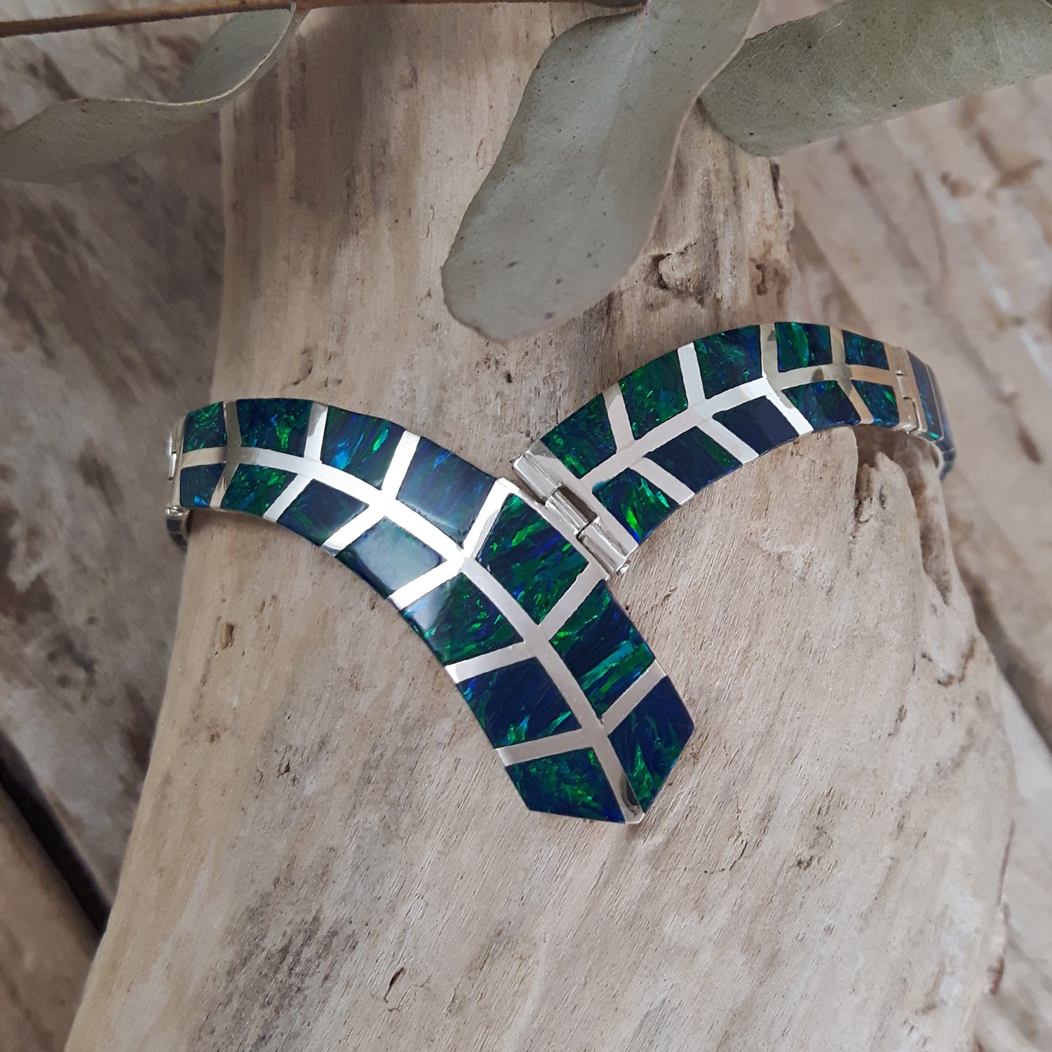 Emerald cultured opal and 925 sterling silver bracelet on a wooden surface
