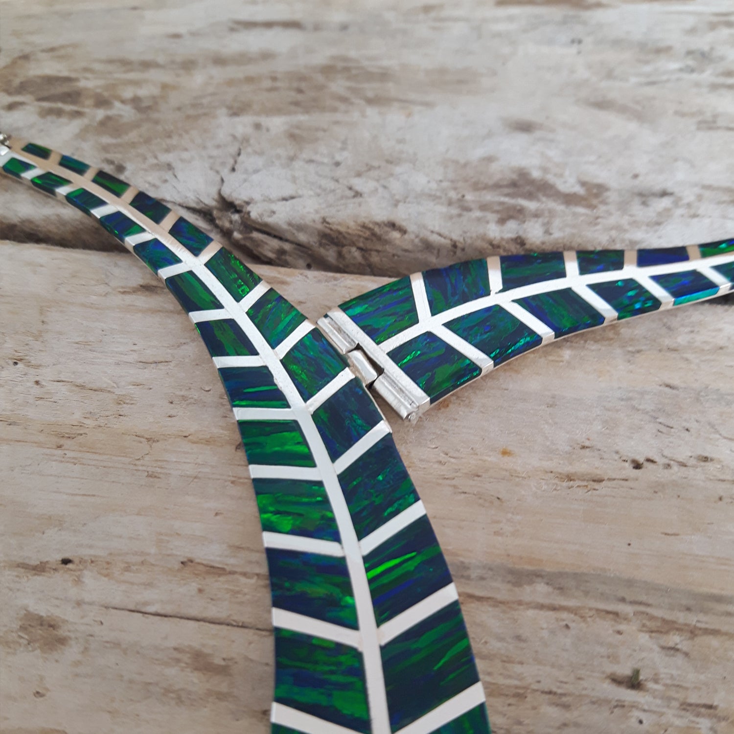 Close-up of the Rio emerald cultured opal necklace on a wooden surface