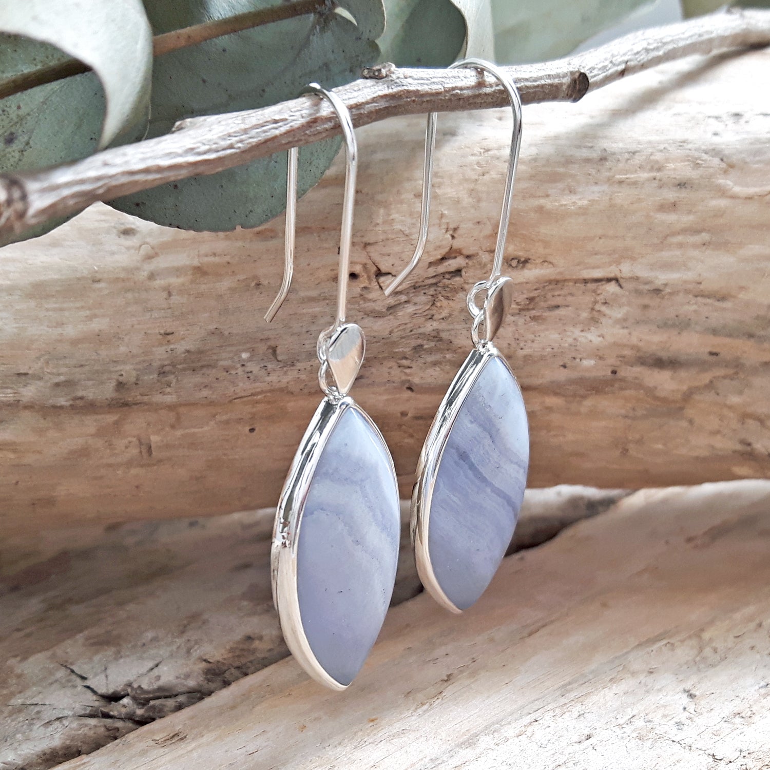 Sterling silver earrings with blue agate stone drops on a wooden branch, British designed
