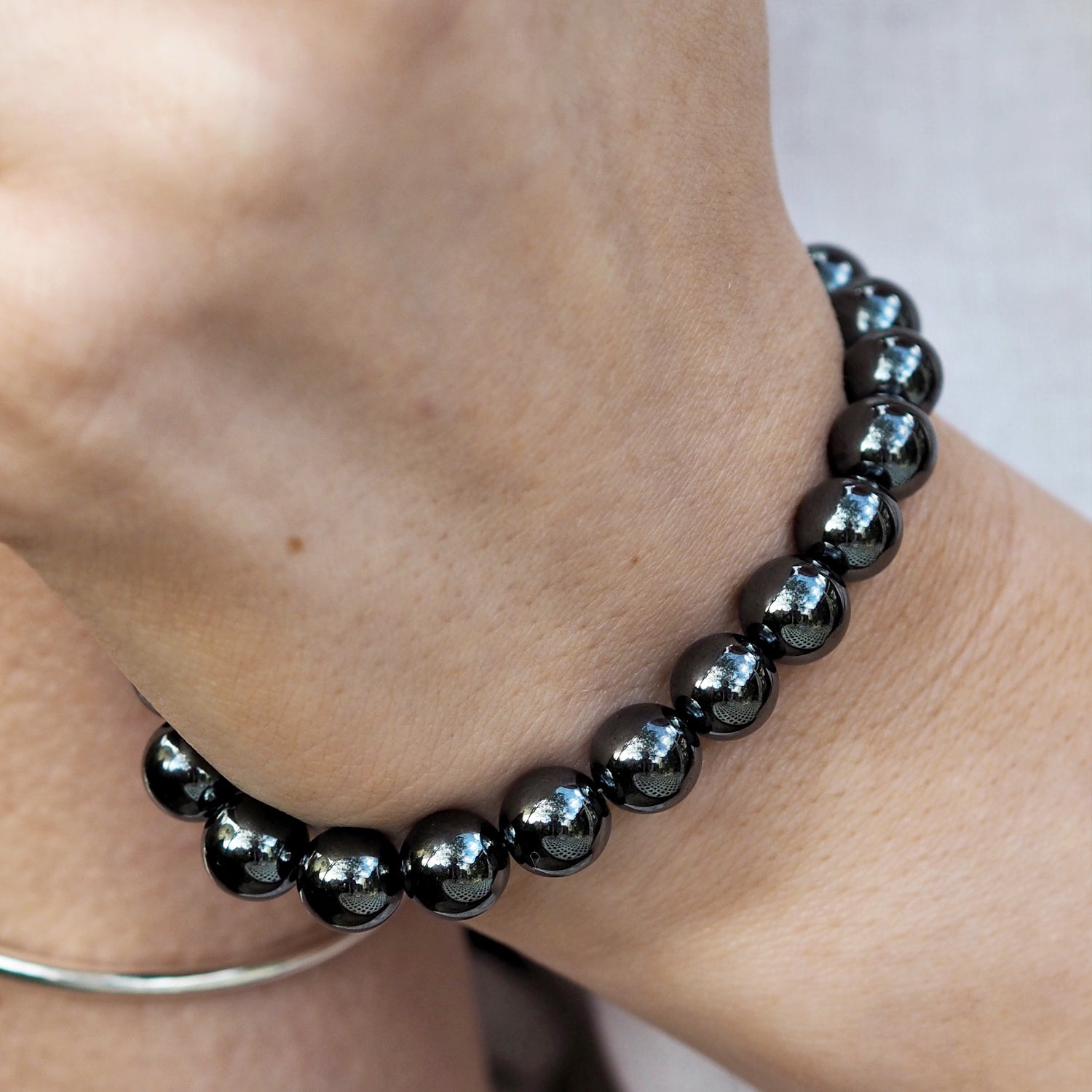 Woman wearing a handcrafted hematite gemstone bracelet designed in the UK