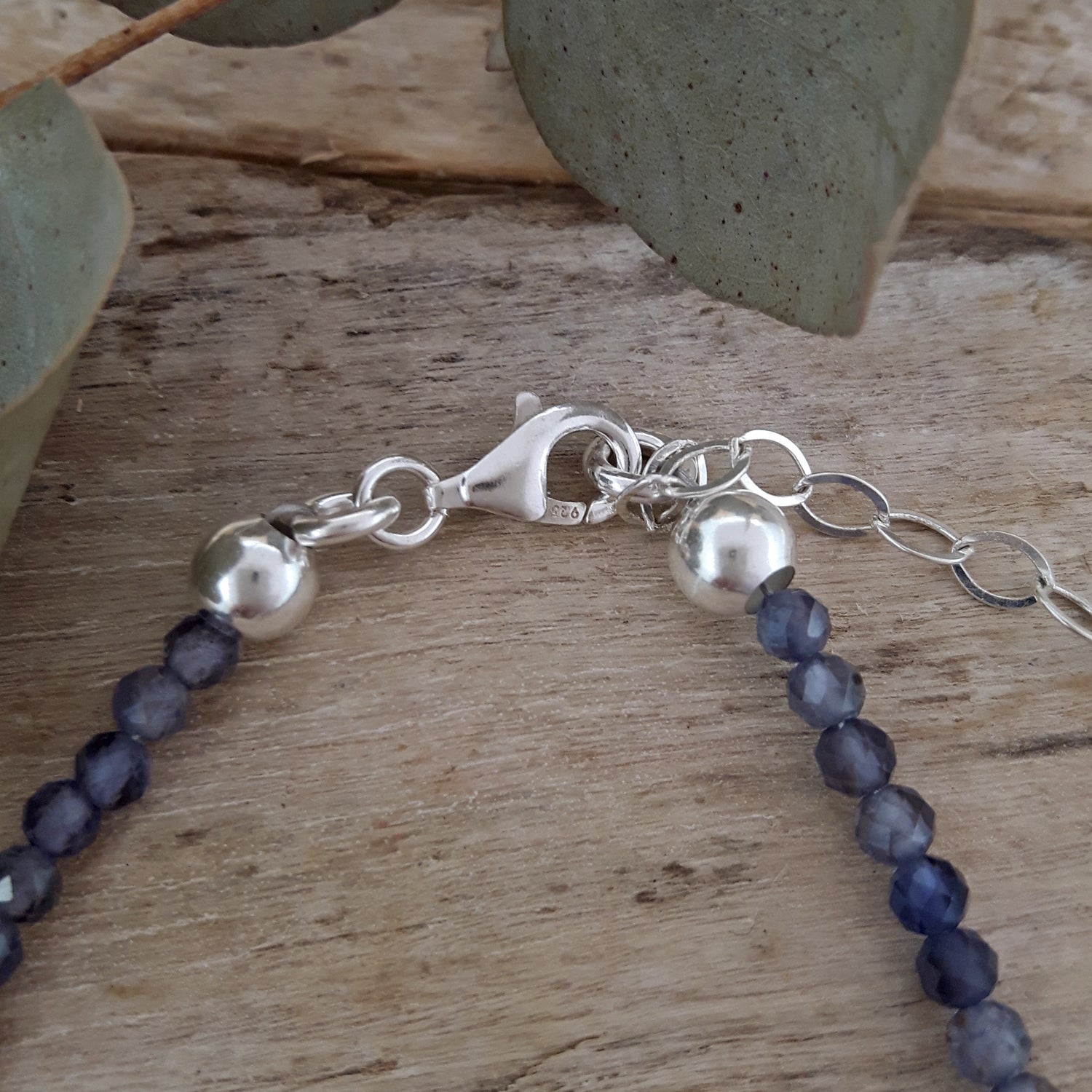 Sterling silver bracelet with iolite beads on a wooden surface