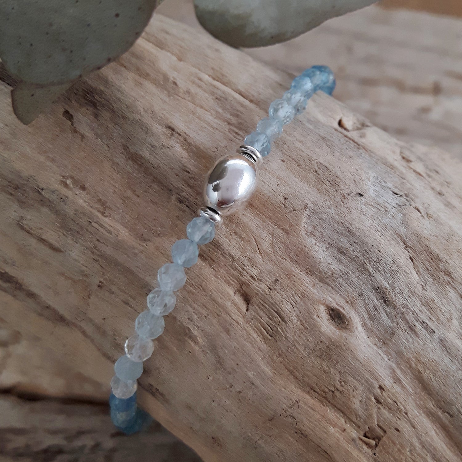 Bracelet with aquamarine beads on a wooden surface