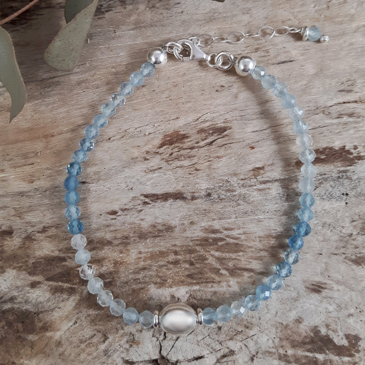 Beaded bracelet with aquamarine stones on a wooden surface