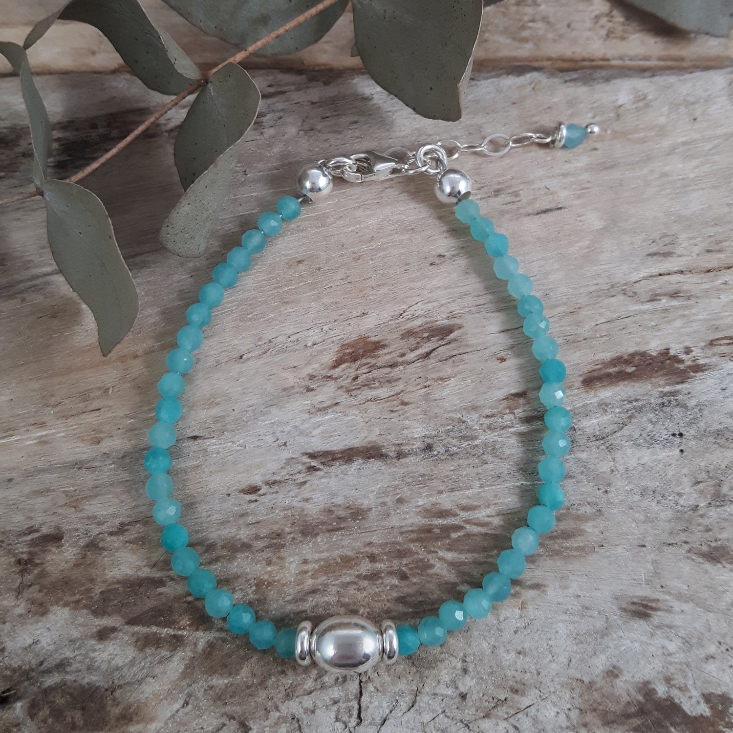 Amazonite beaded bracelet with sterling silver beads on a wooden surface