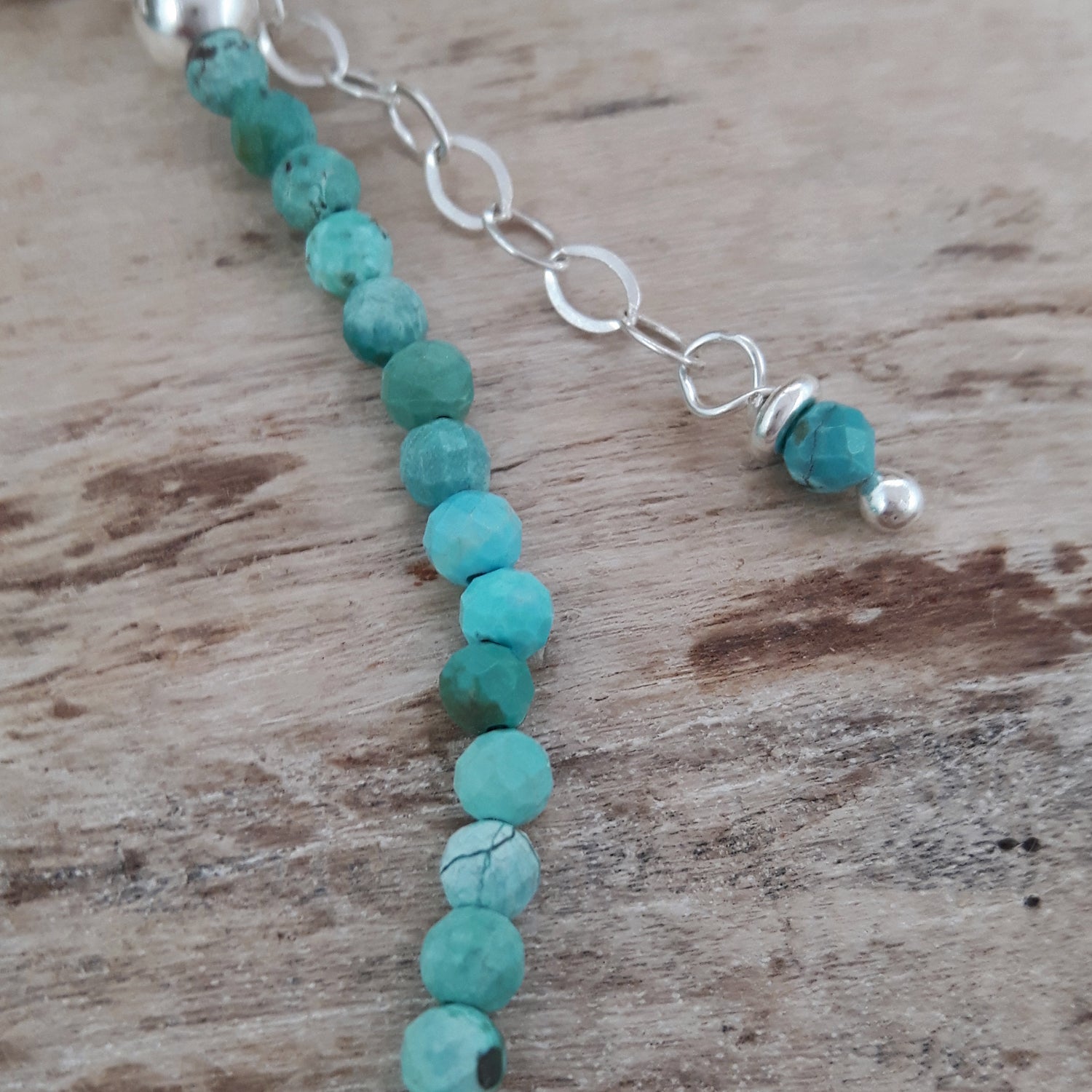 Handmade turquoise gemstone beaded bracelet on a wooden surface