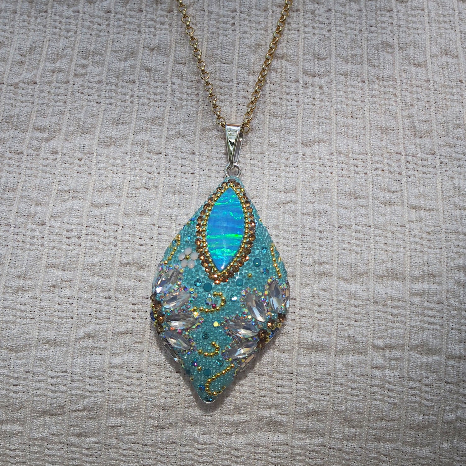close up opal pendant crystal and micro bead detail worn with a white dress