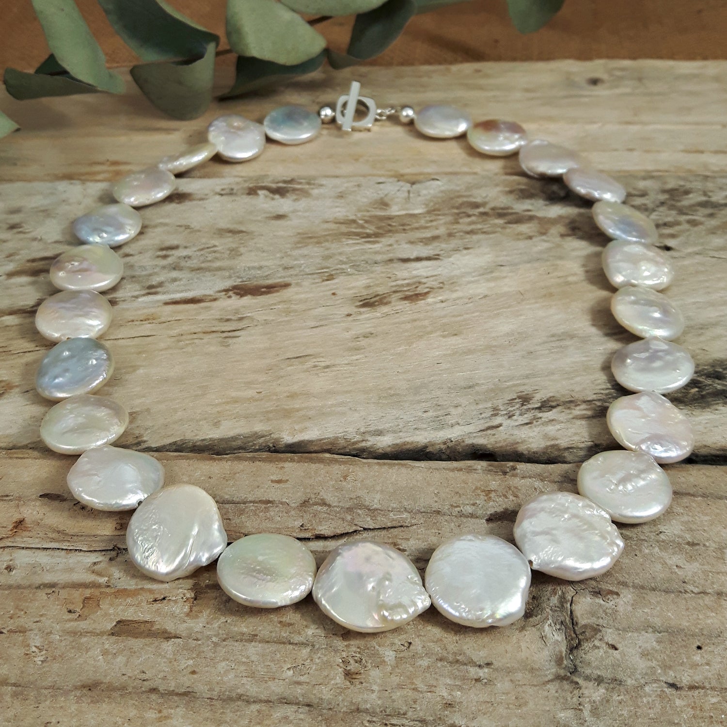 Necklace with large, round, white pearls on a wooden surface