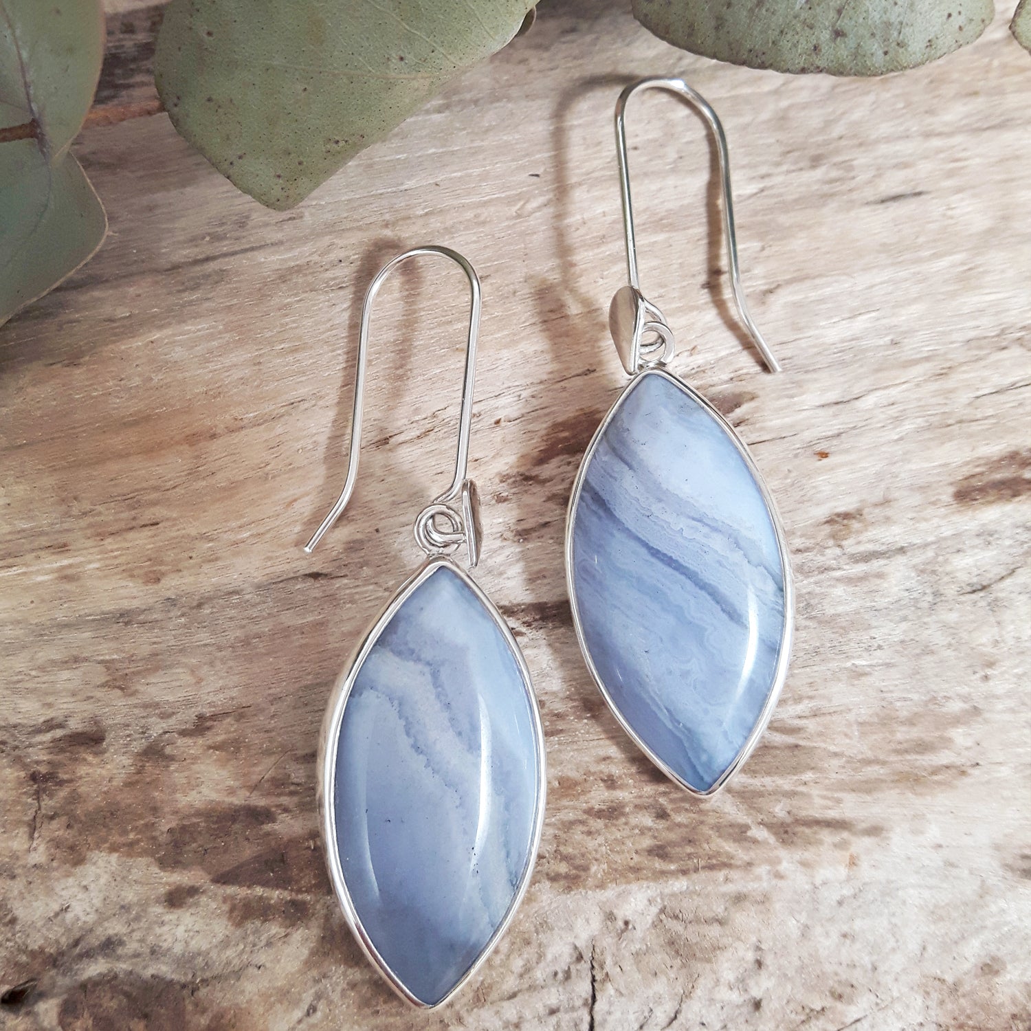 Blue lace marbled earrings on a wooden surface with eucalyptus leaves, by Palenque.