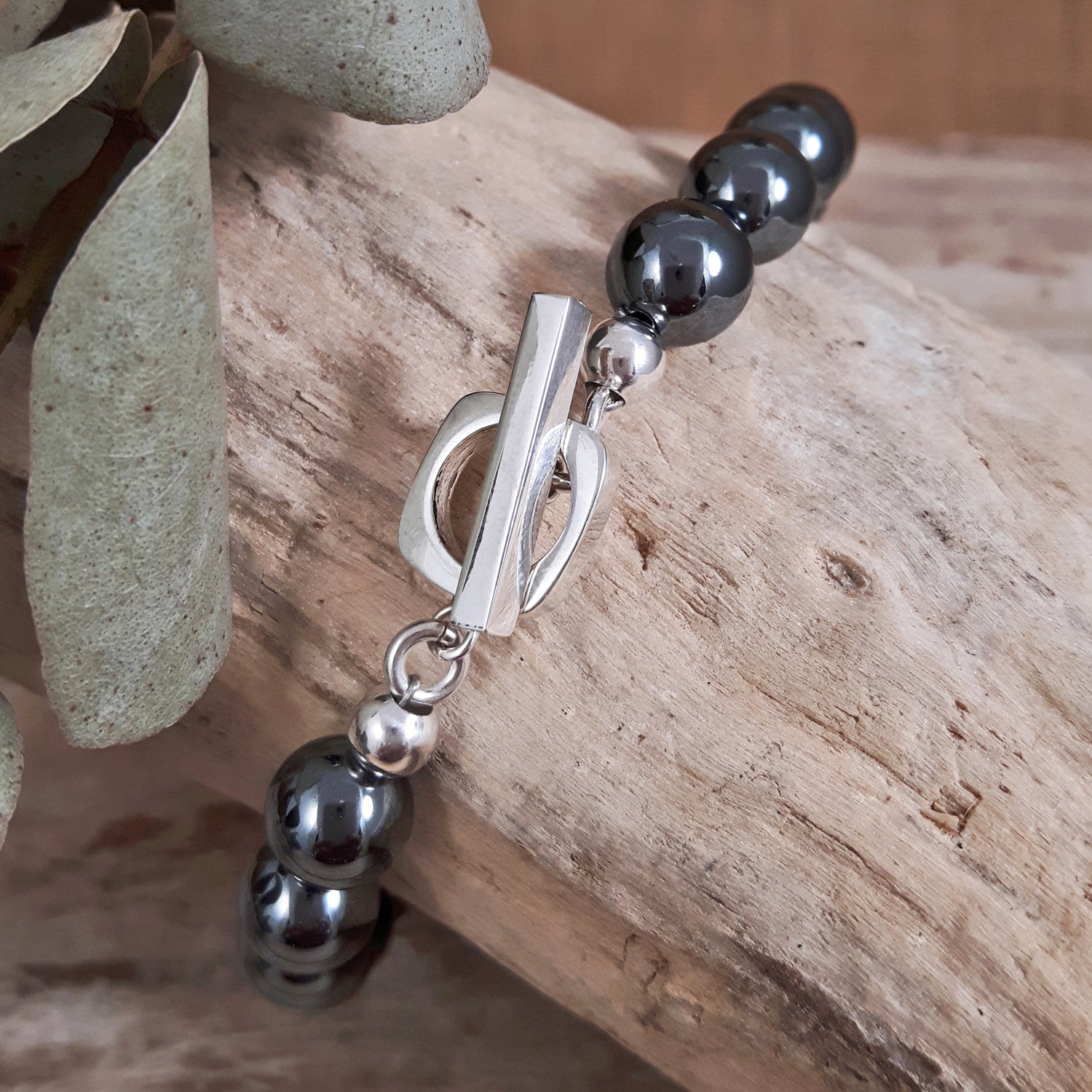 Layering contemporary bracelet with black hematite beads and a silver t-bar detail 