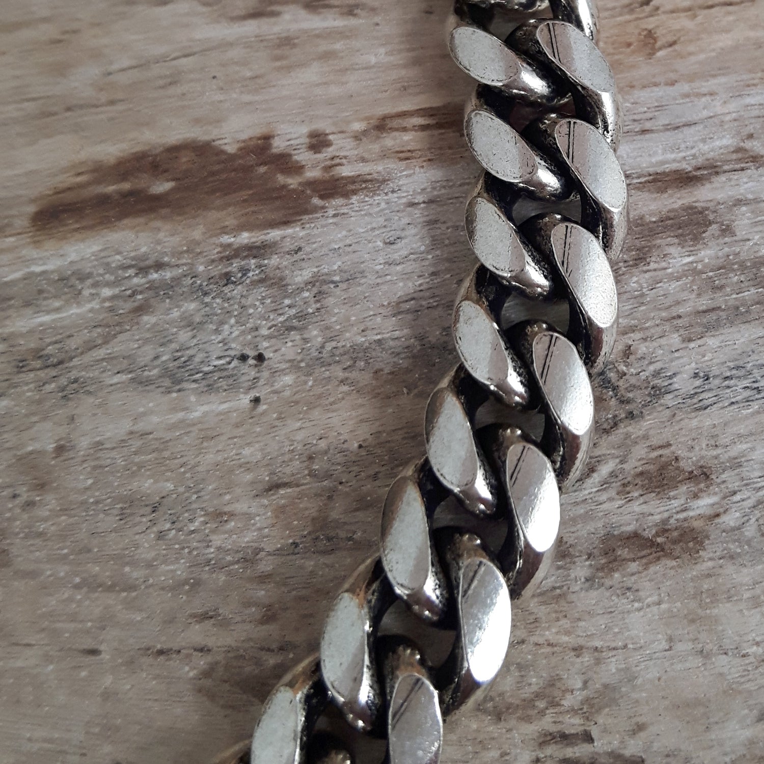 Close-up of a sterling silver chain on a wooden surface