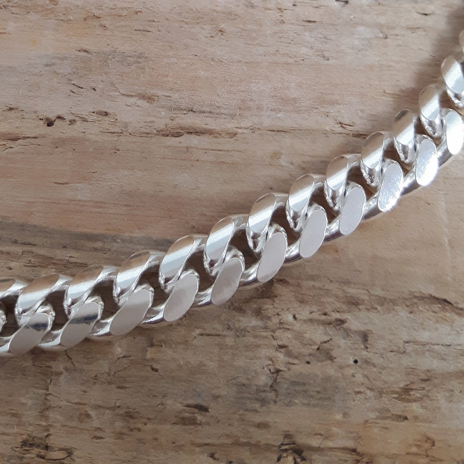Mens sterling silver chain on a wooden surface