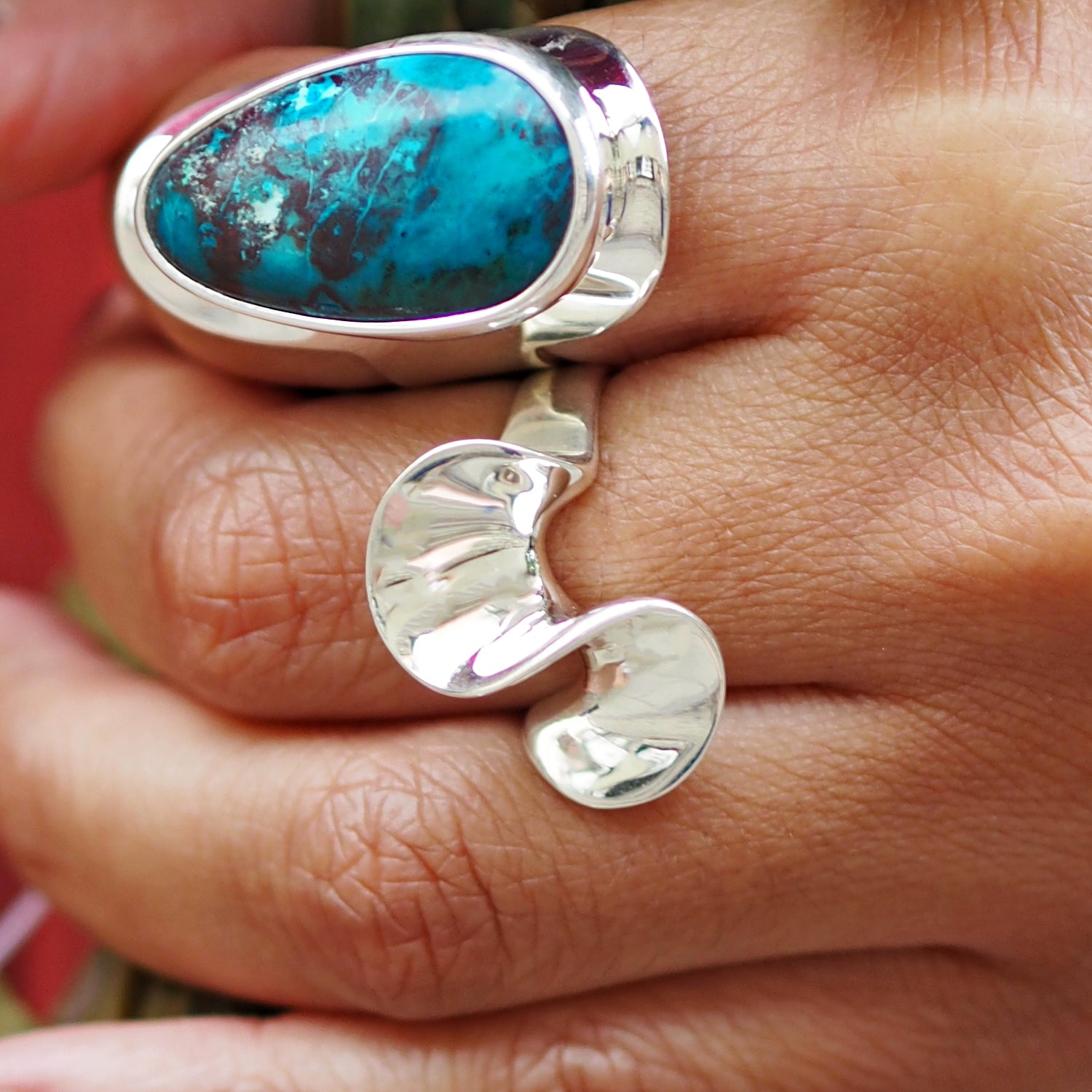 Polished sterling silver ring with a Shuttakite stone on a hand