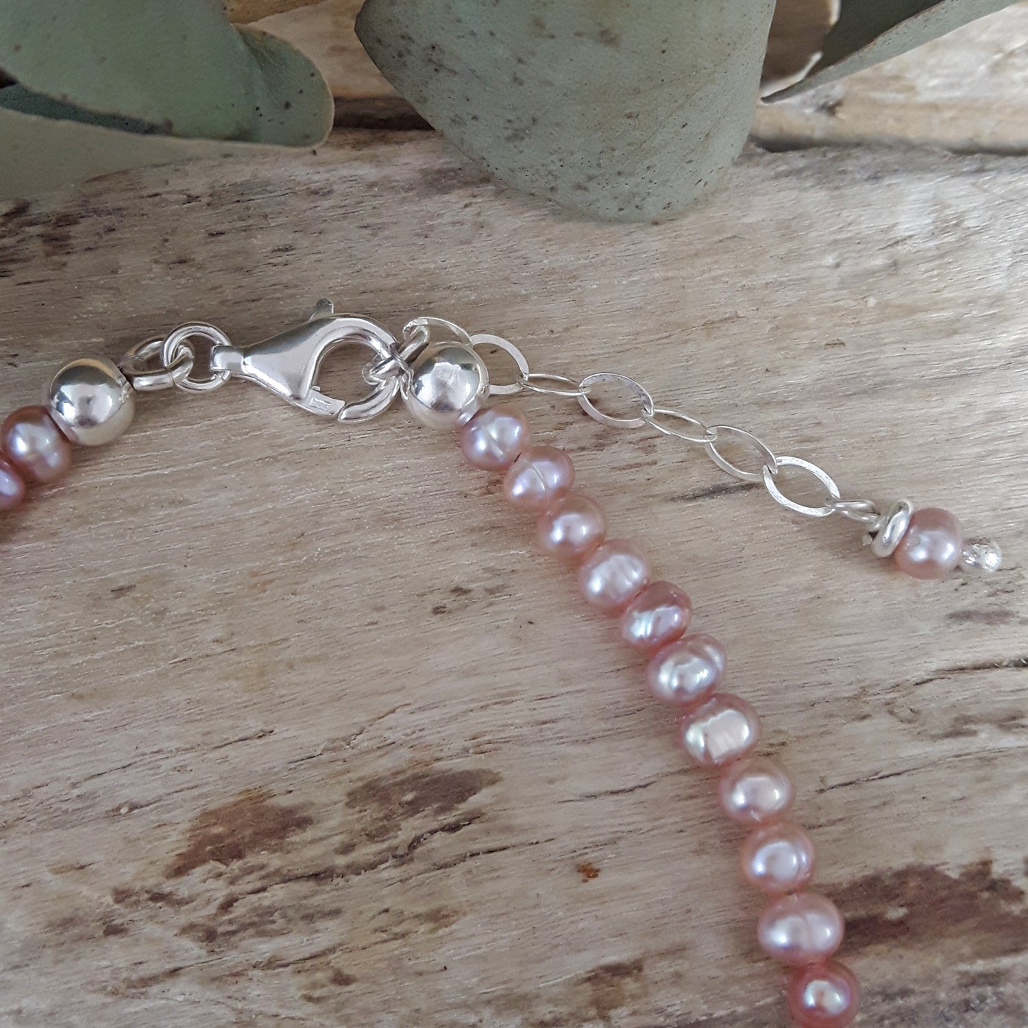 Pearl bracelet with silver clasp on a wooden surface