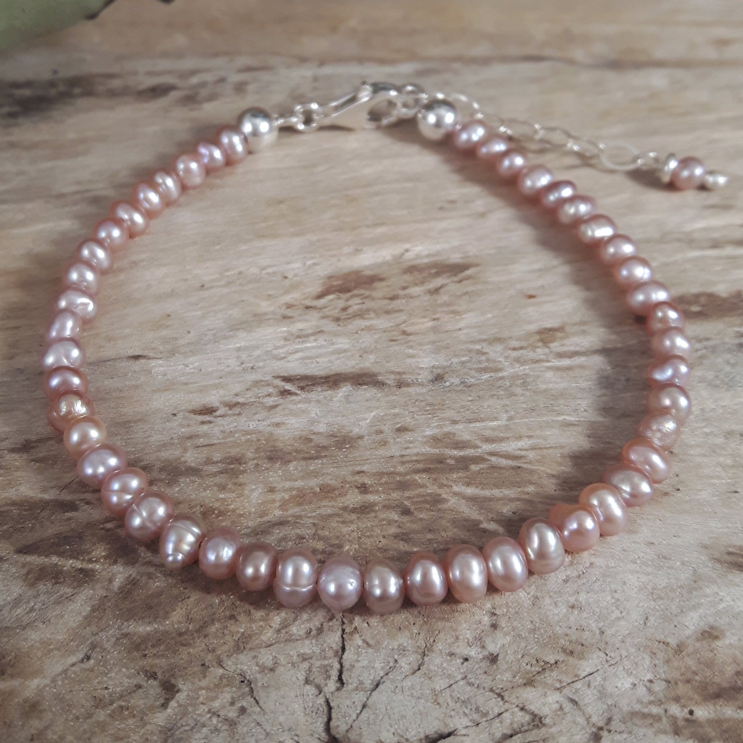 Pink pearl bracelet on a wooden surface