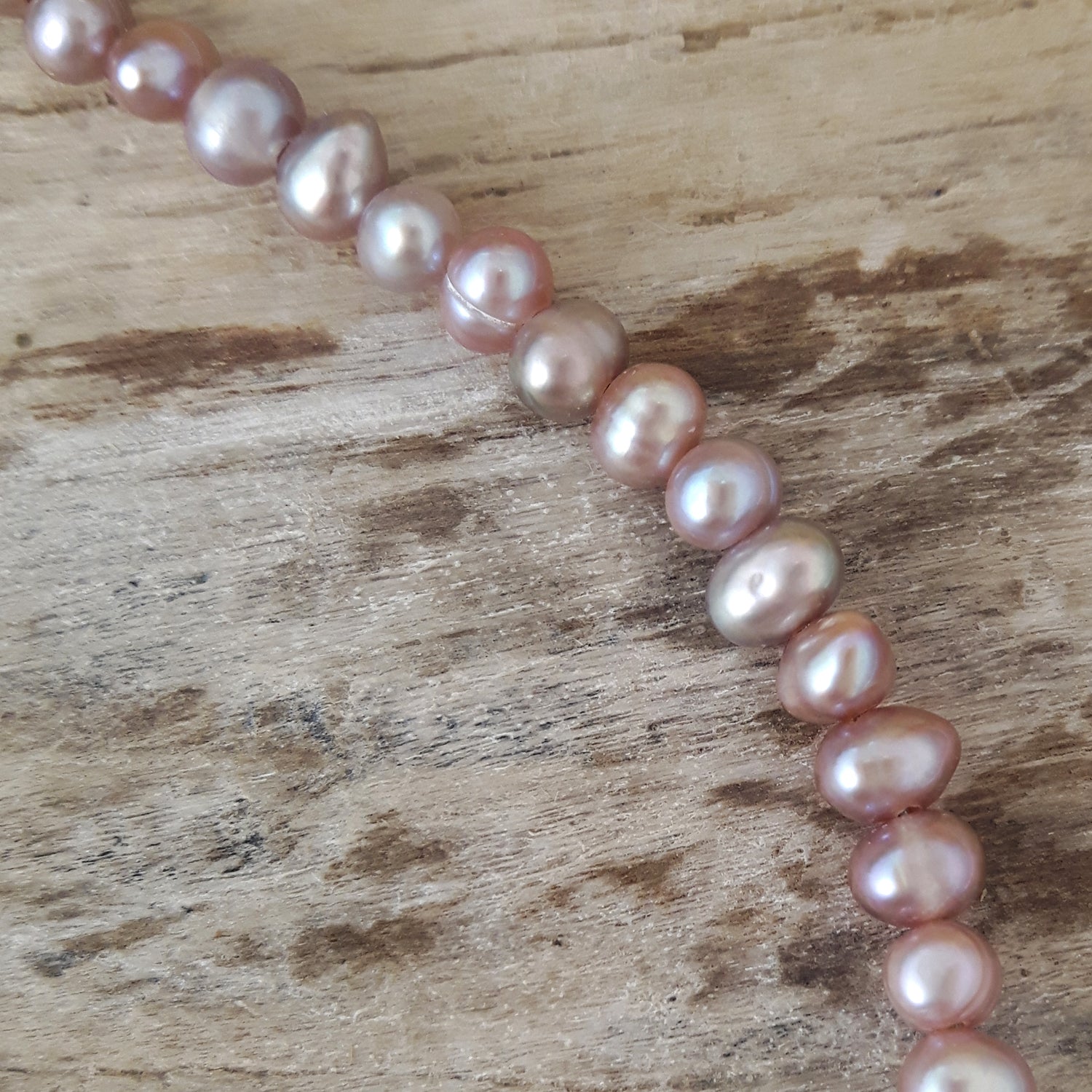 Close-up of pearl necklace on a wooden surface