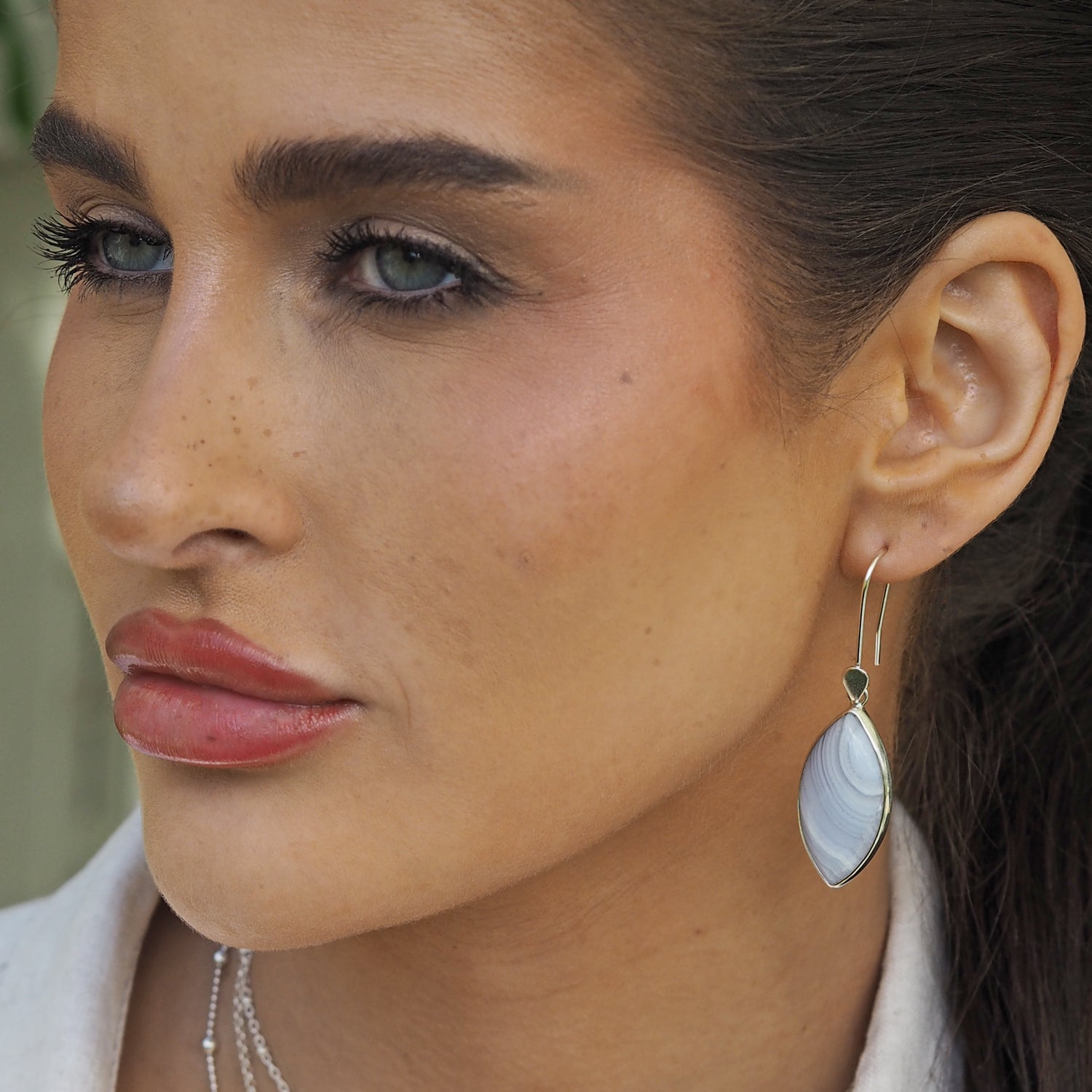 Hand-picked blue lace agate stone earrings with silver detail showing scale when worn. Gifts under £150