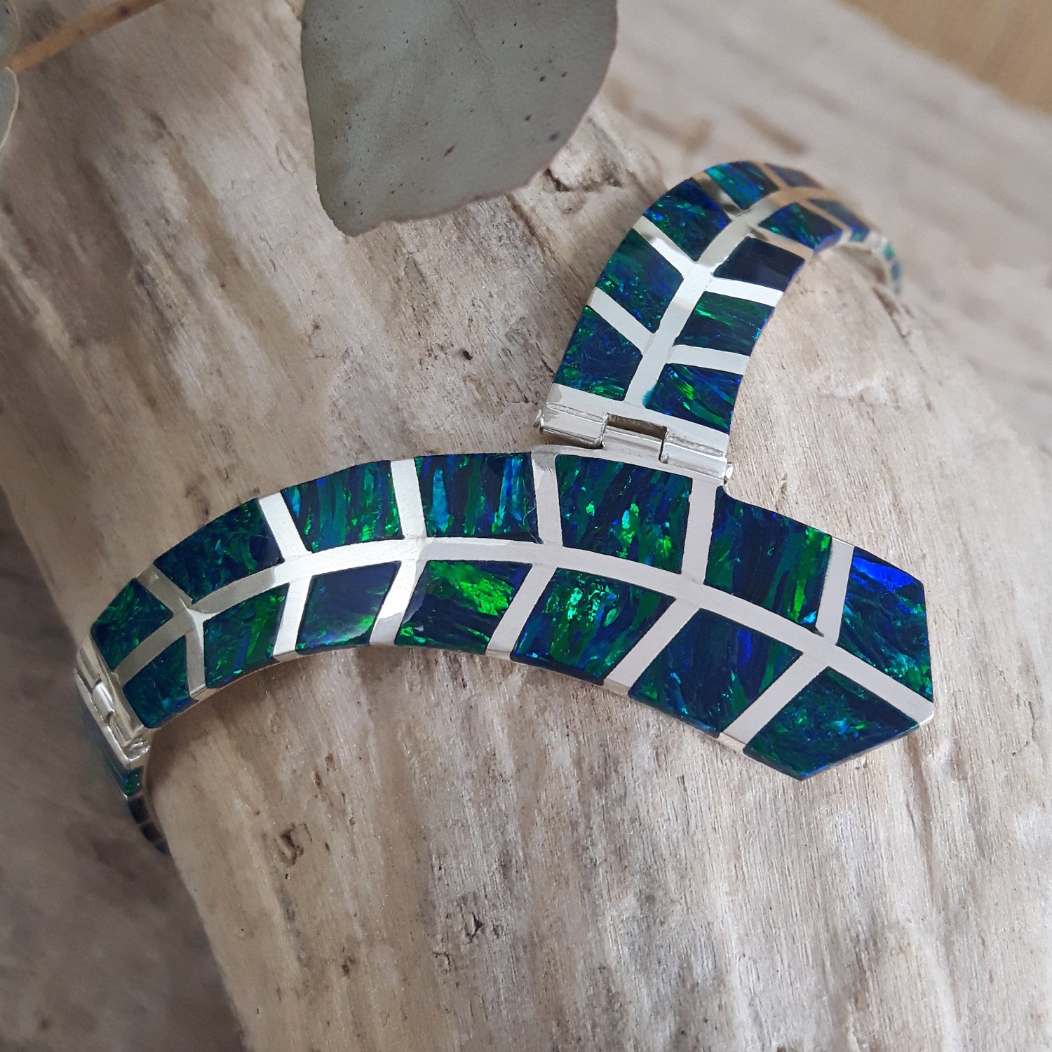 Unique emerald cultured opal sterling silver  bracelet on a wooden surface