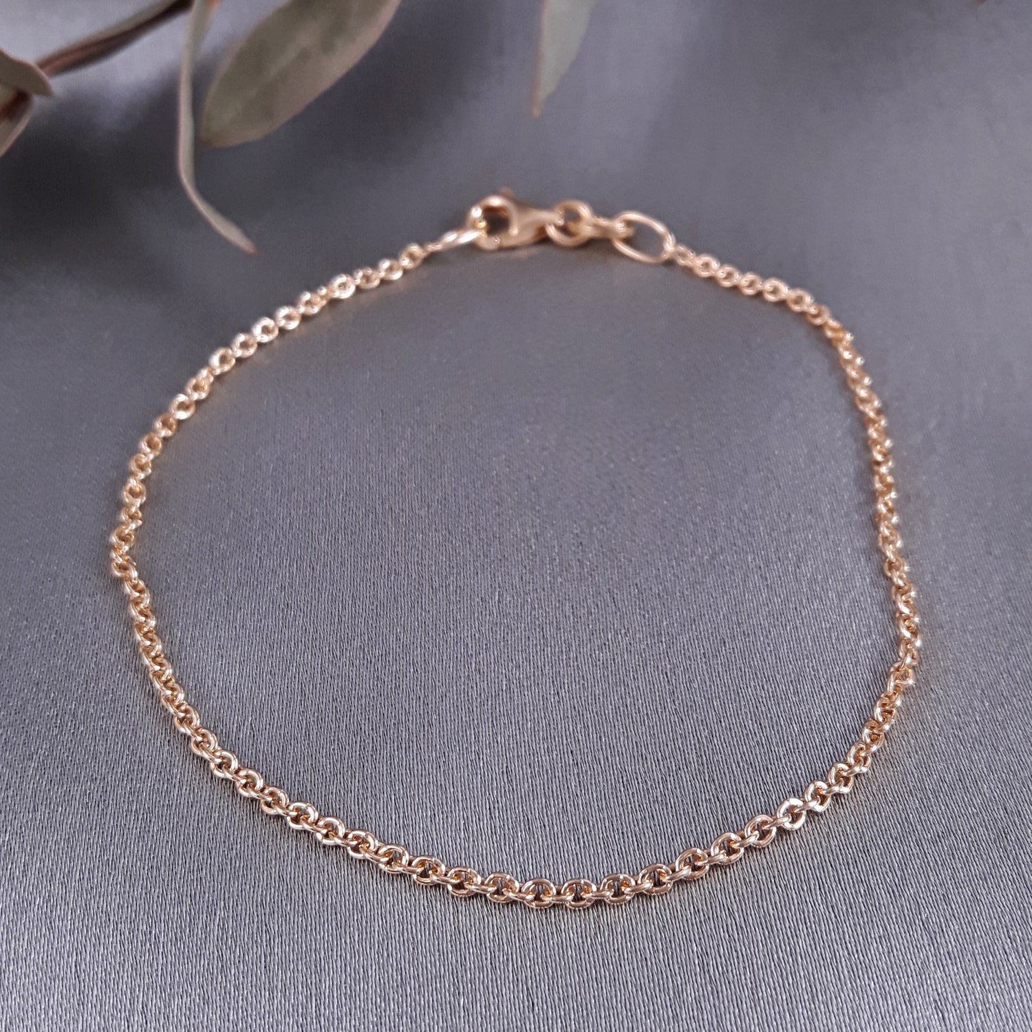 Rose gold bracelet on a gray fabric background