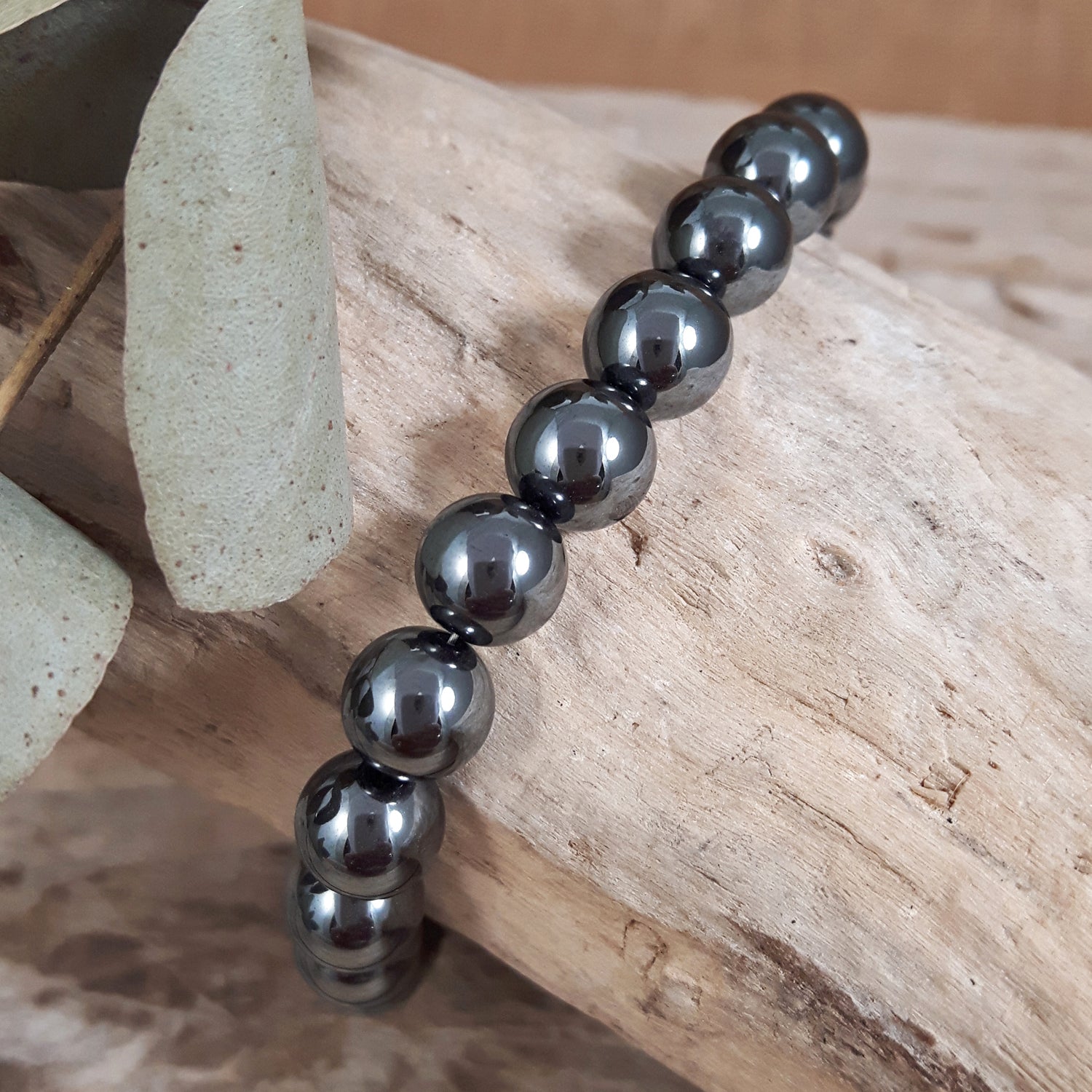 Black hematite beaded bracelet on a wooden surface UK gemstone jewellery
