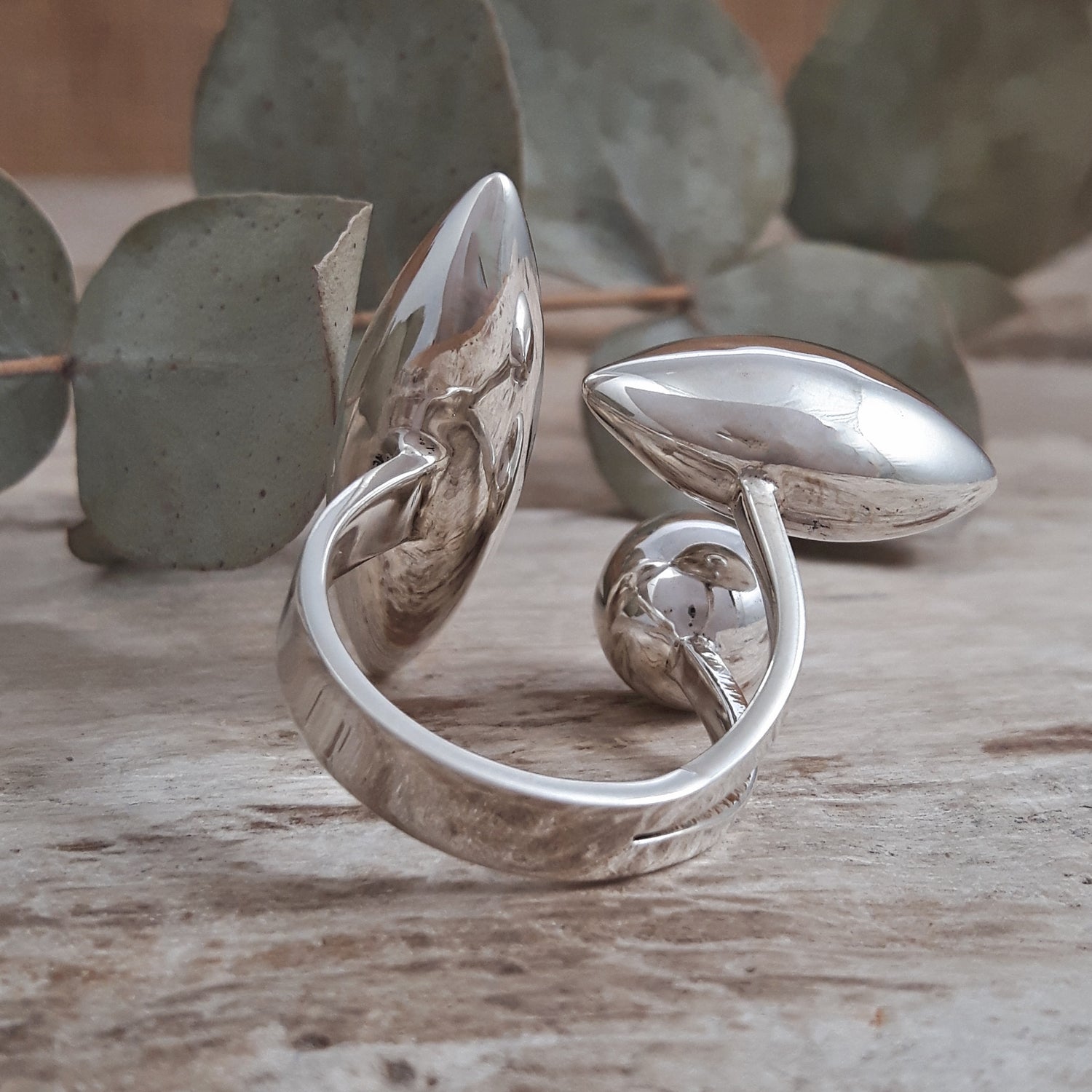 Sterling silver ring with leaf design on a wooden surface