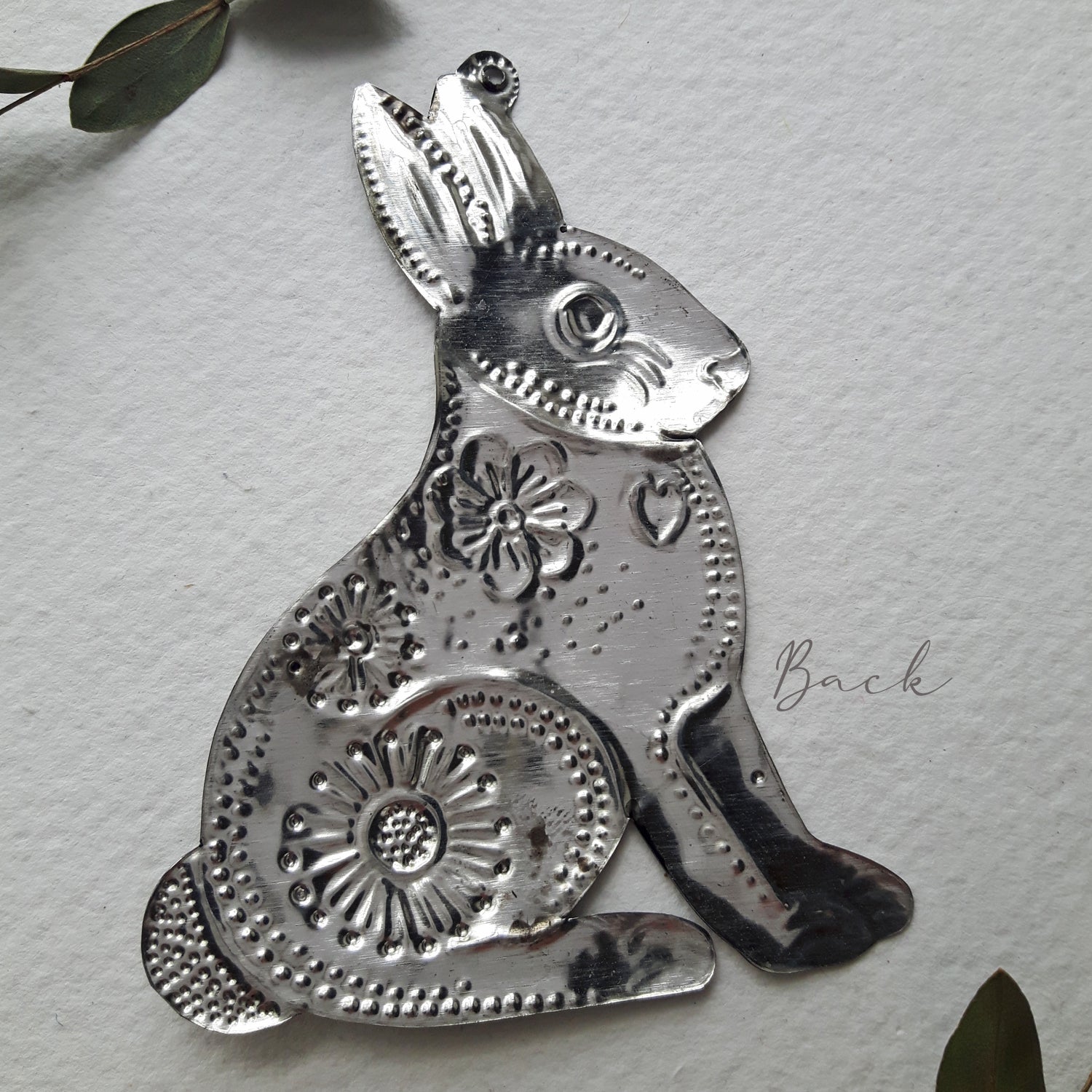 Decorative metal rabbit on a textured light gray background