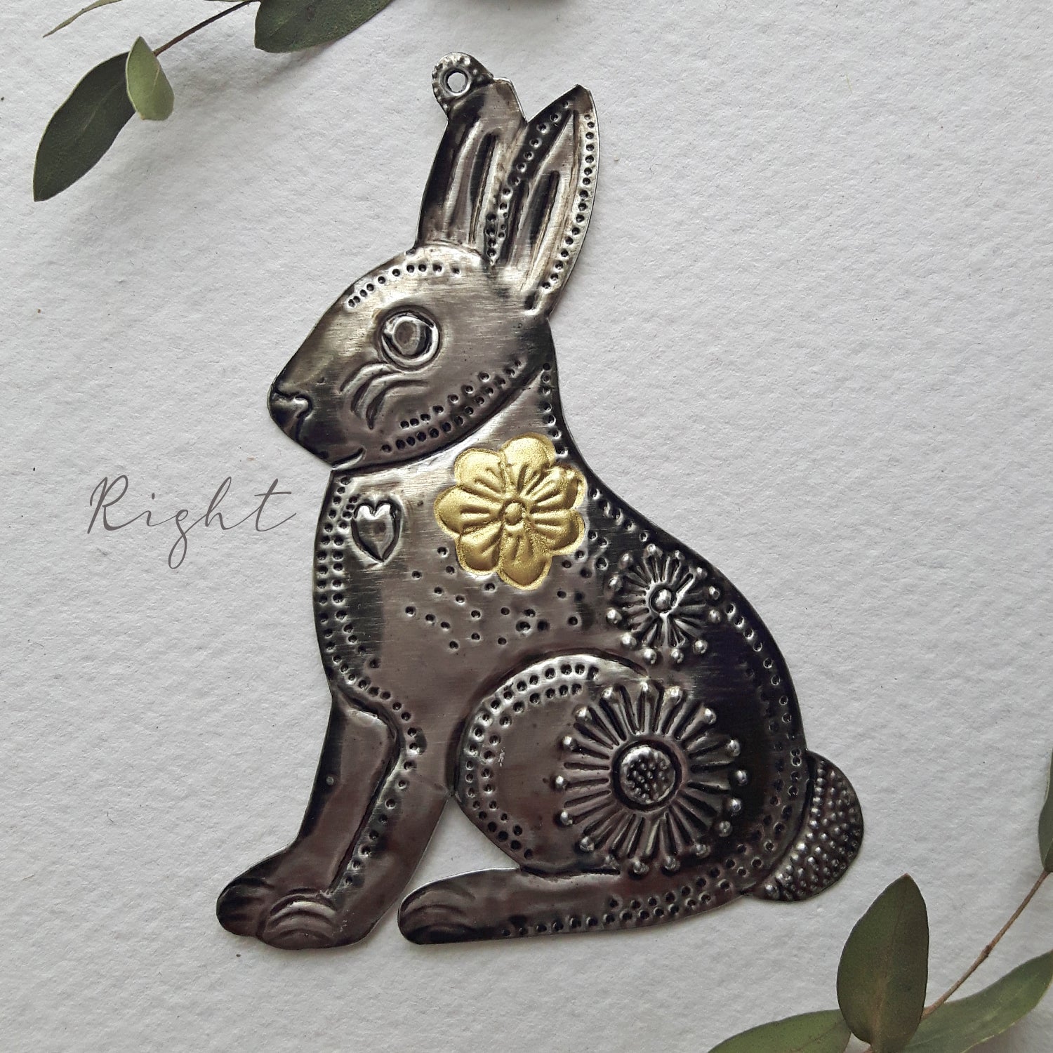 Decorative metal rabbit with floral and geometric patterns on a light gray background