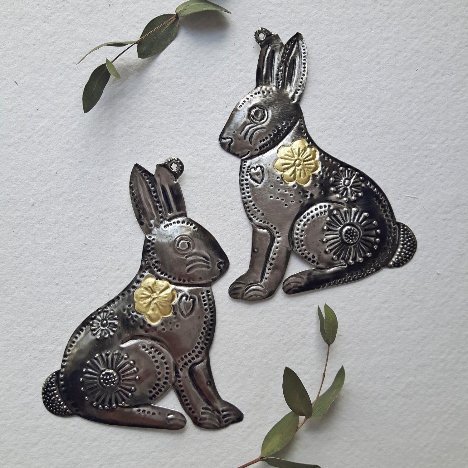Decorative metal rabbit wall art with gold accents on a light gray background.