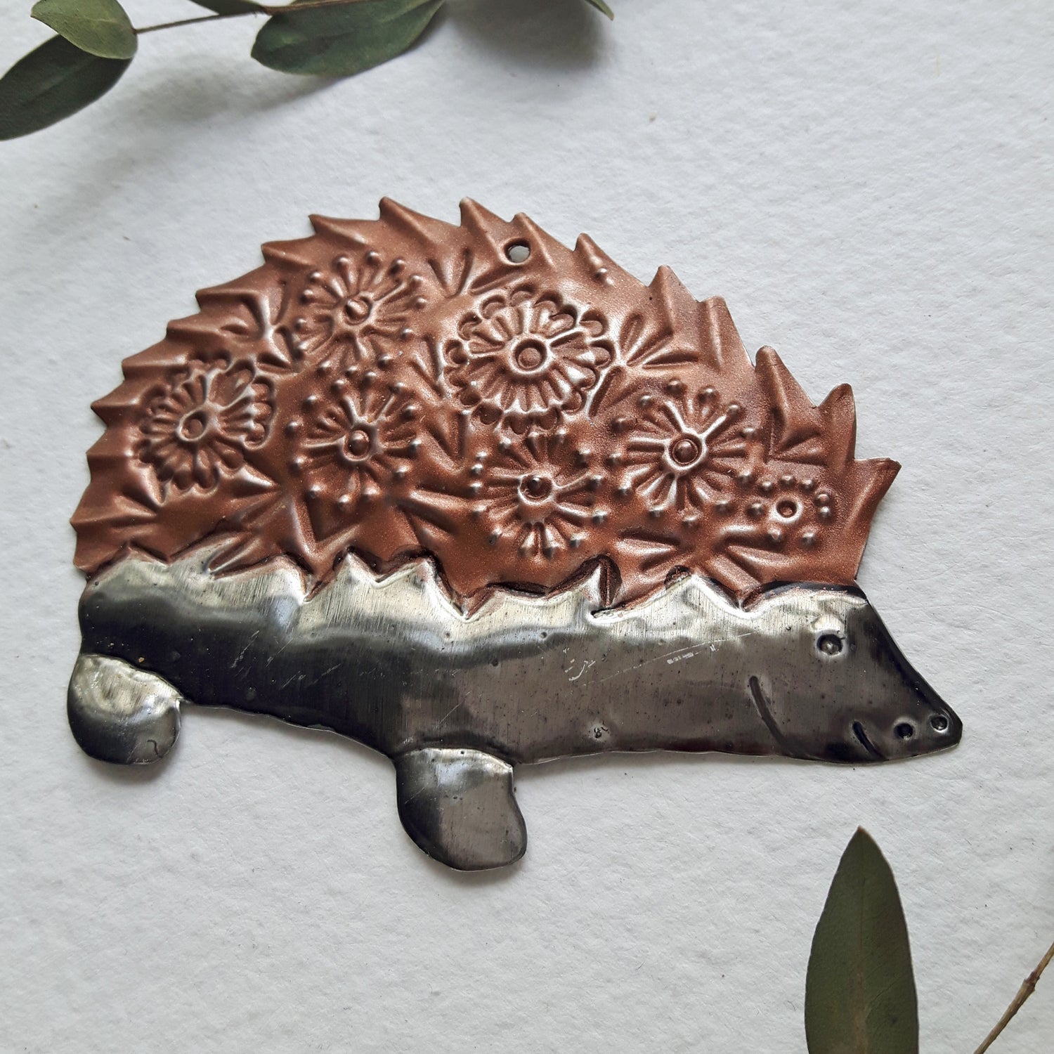 Decorative hedgehog ornament with floral patterns on a light gray background