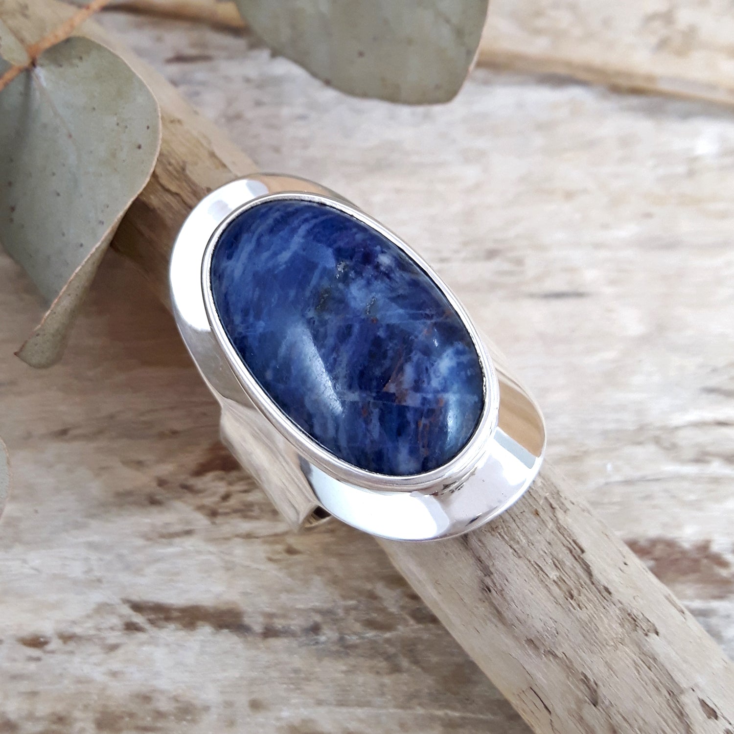 Sterling silver ring with a blue sodalite stone on a wooden surface