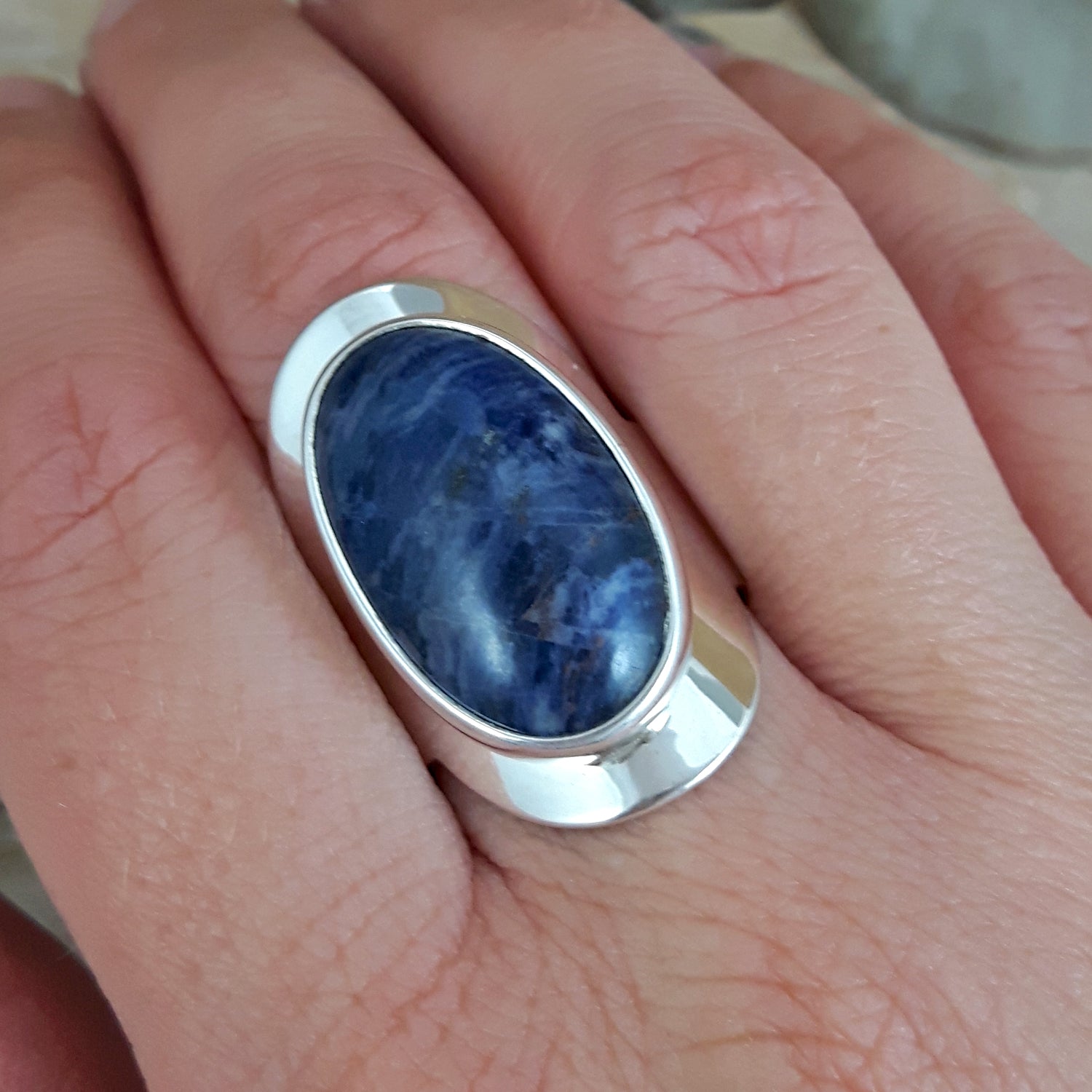Monet Sodalite Oval ring set in sterling silver on a person's finger