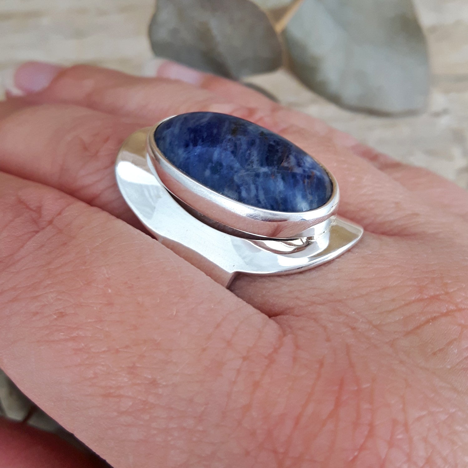 Sterling silver ring with a blue stone on a hand